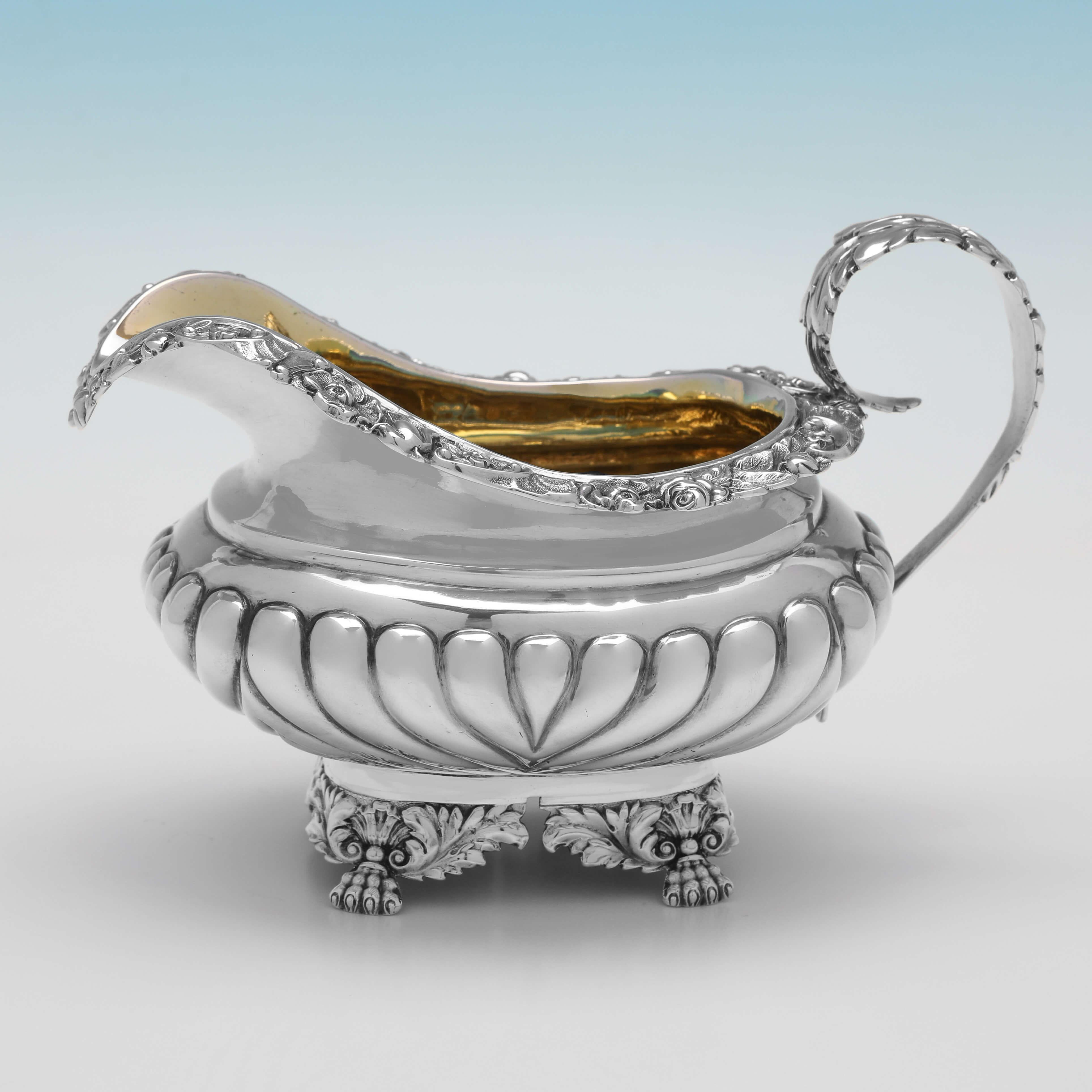 Hallmarked in London in 1828 by Charles Fox II, this delightful, George IV, Antique Sterling Silver Tea Set, features converged fluting, silver handles and gilt interiors to the sugar and cream. The teapot measures 6.25