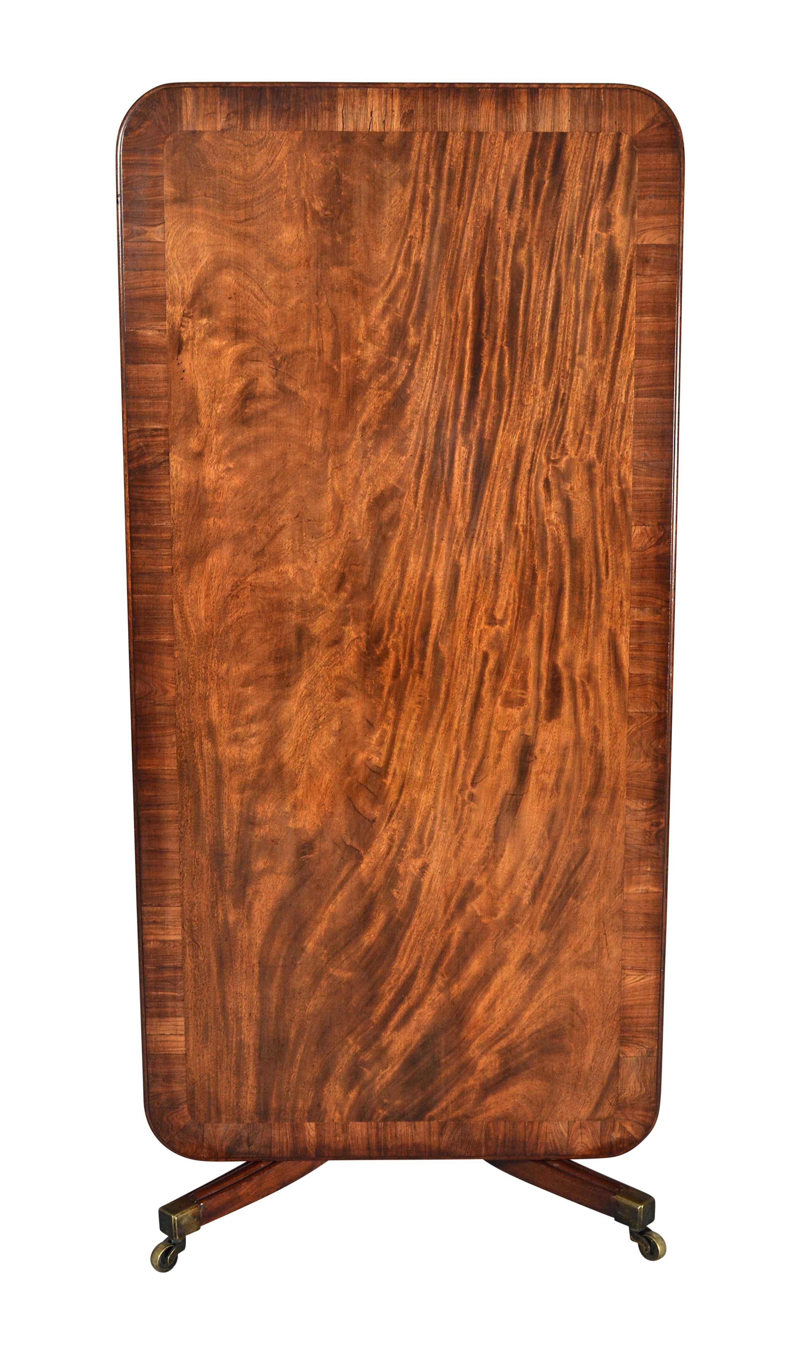 A George IV period mahogany sofa or breakfast table attributed to Dublin maker Williams and Gibton. The rectangular, tilting top has rounded corners and a thick, double-molded edge. The beautifully figured mahogany is outlined by a strip of rosewood