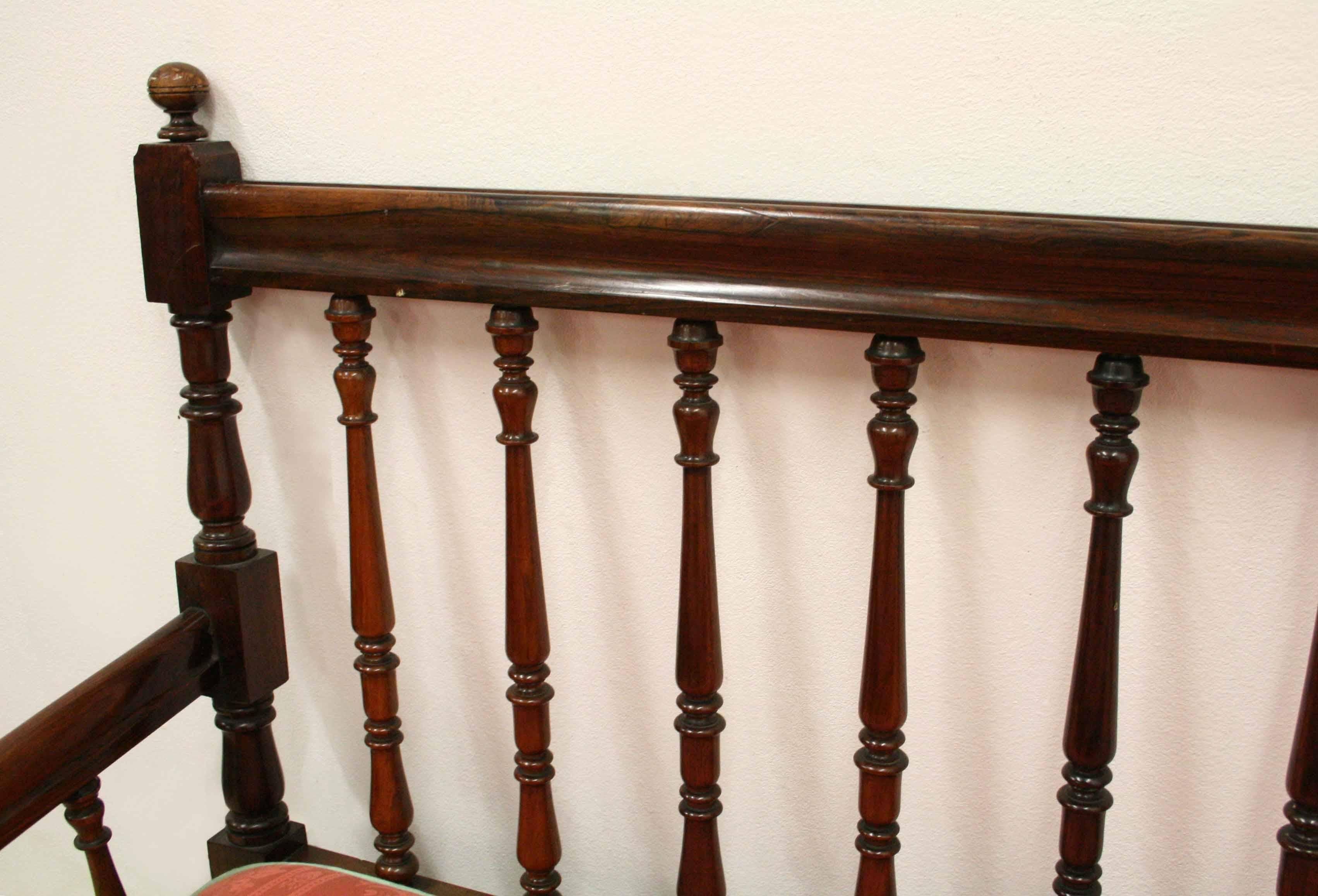 Very unusual and stylish George IV solid rosewood two-seat sofa with two removable cushions, circa 1825. At the back of the sofa there are two turned uprights finished with finials. The top rail has various shaped double ogee mouldings and beneath