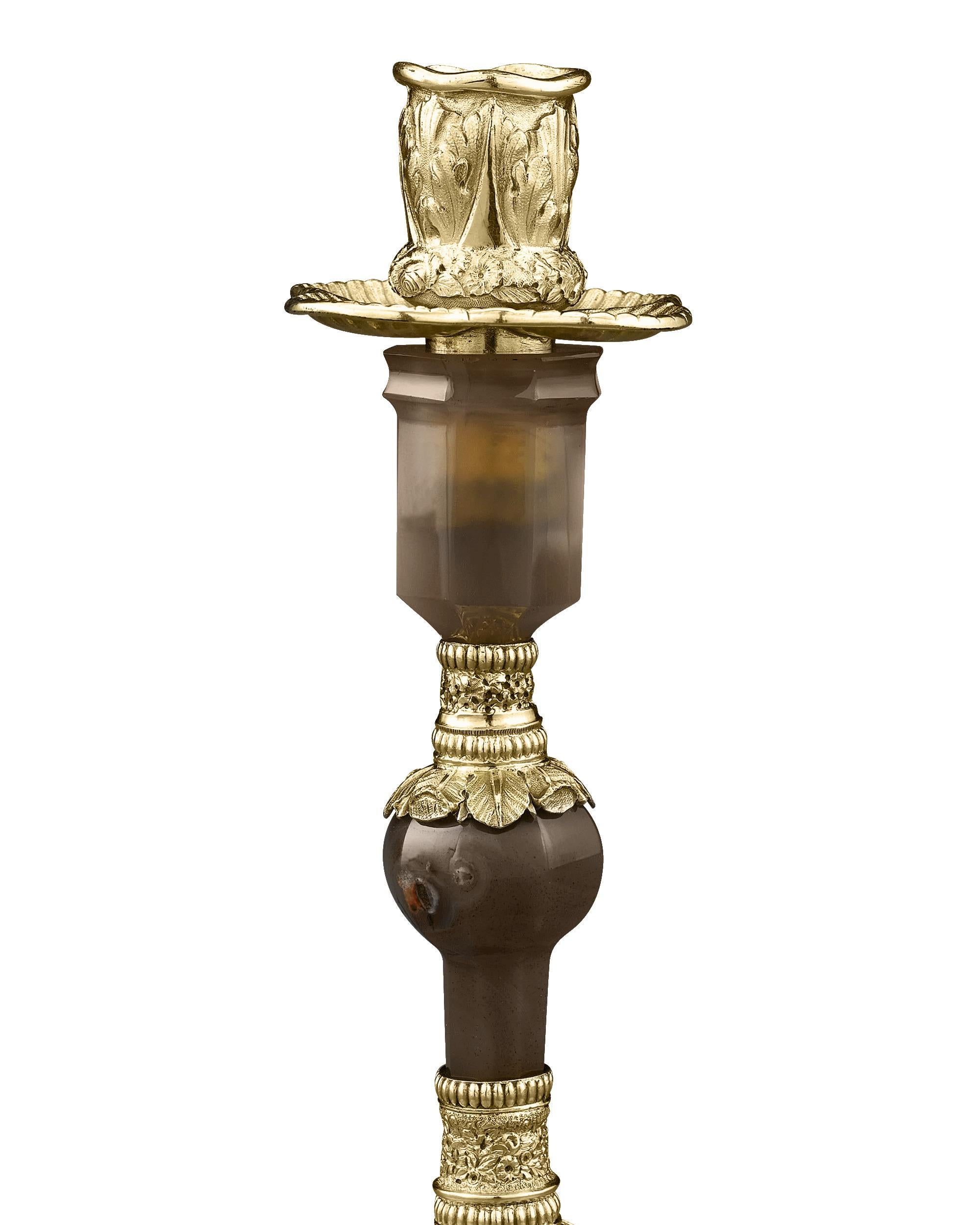 This incredibly rare pair of antique candlesticks, comprised of beautifully polished agate stone mounted in gilded silver, was crafted by Edward Farrell, one of the finest craftsmen working in the Rococo Revival style. Opulent yet well-balanced,