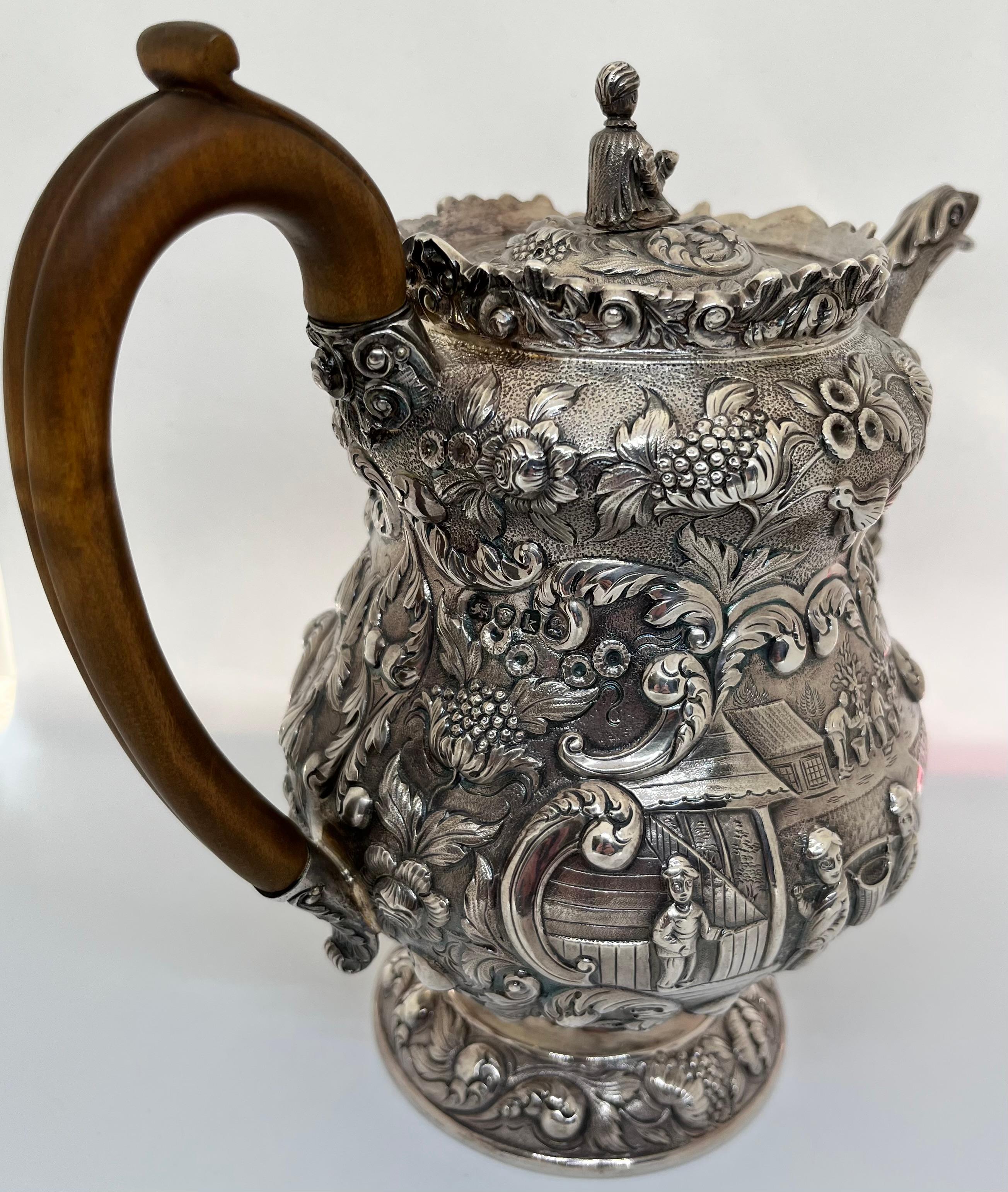 A fine quality and extremely rare George IV sterling silver Regency tea or coffee pot, profusely and skilfully decorated with panels of pastoral scenes depicting the Chinese tea harvest with figures picking tea leaf plants, sorting and transporting