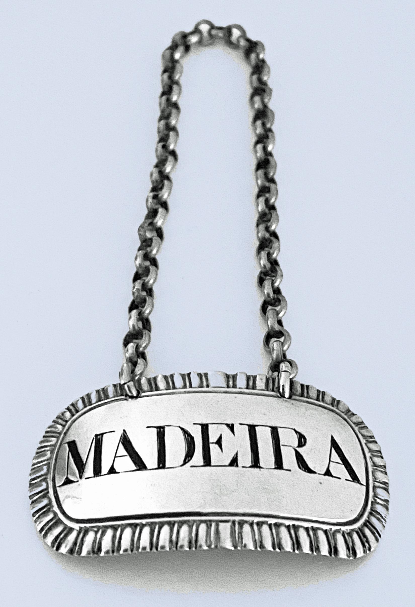 George IV silver Wine Label Madeira, John Reily London, 1824. The label of rounded rectangular form with gadrooned border, incised for Madeira. Measures: 1.90 x 1.20 inches (excluding chain) 