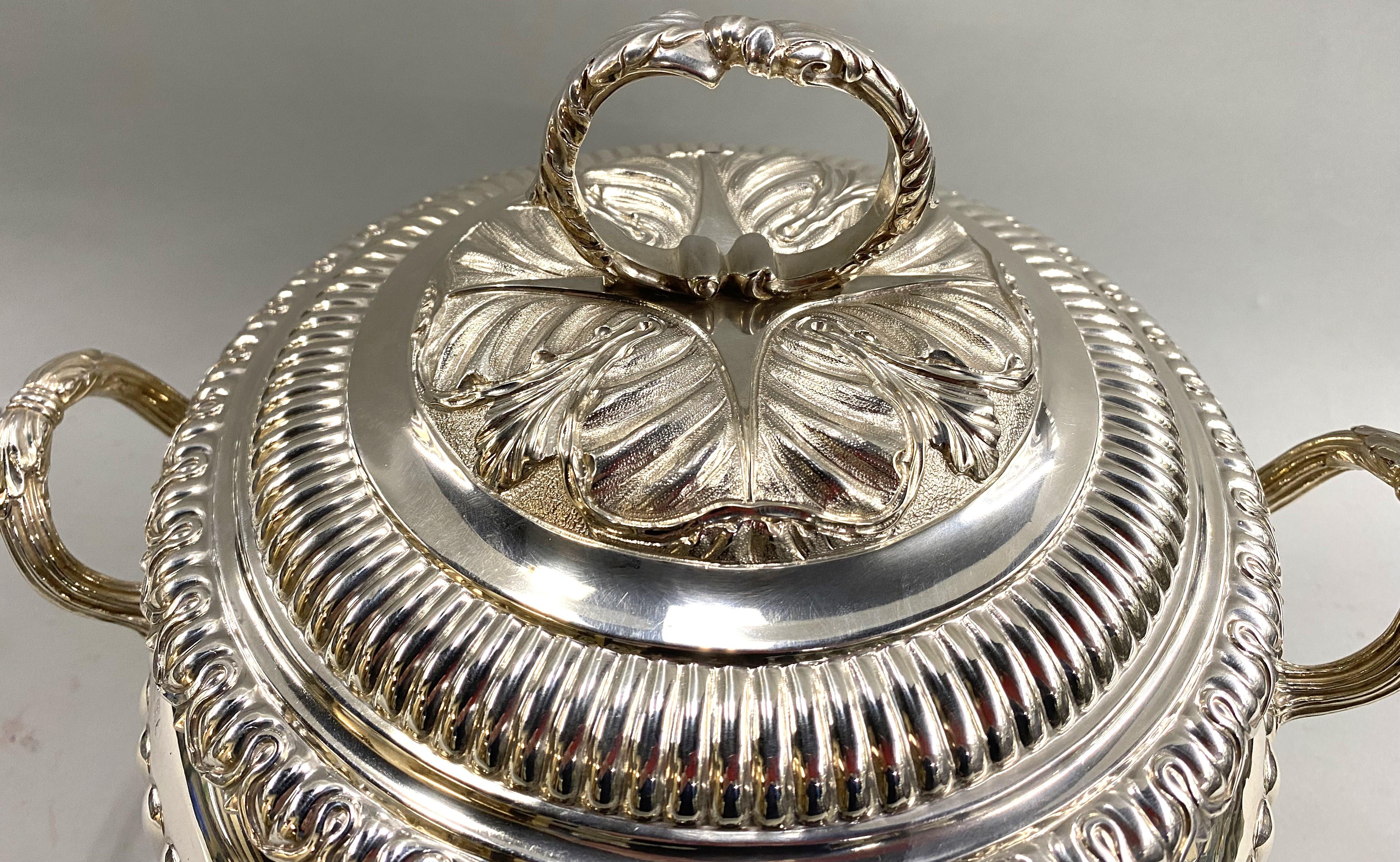 An exceptional sterling silver covered soup tureen with a compressed round body, decorated with flutes, two leaf capped handles, oak leaves, and acorns border two reserves. The base is supported on a fluted Ming foot, while the cover has a central