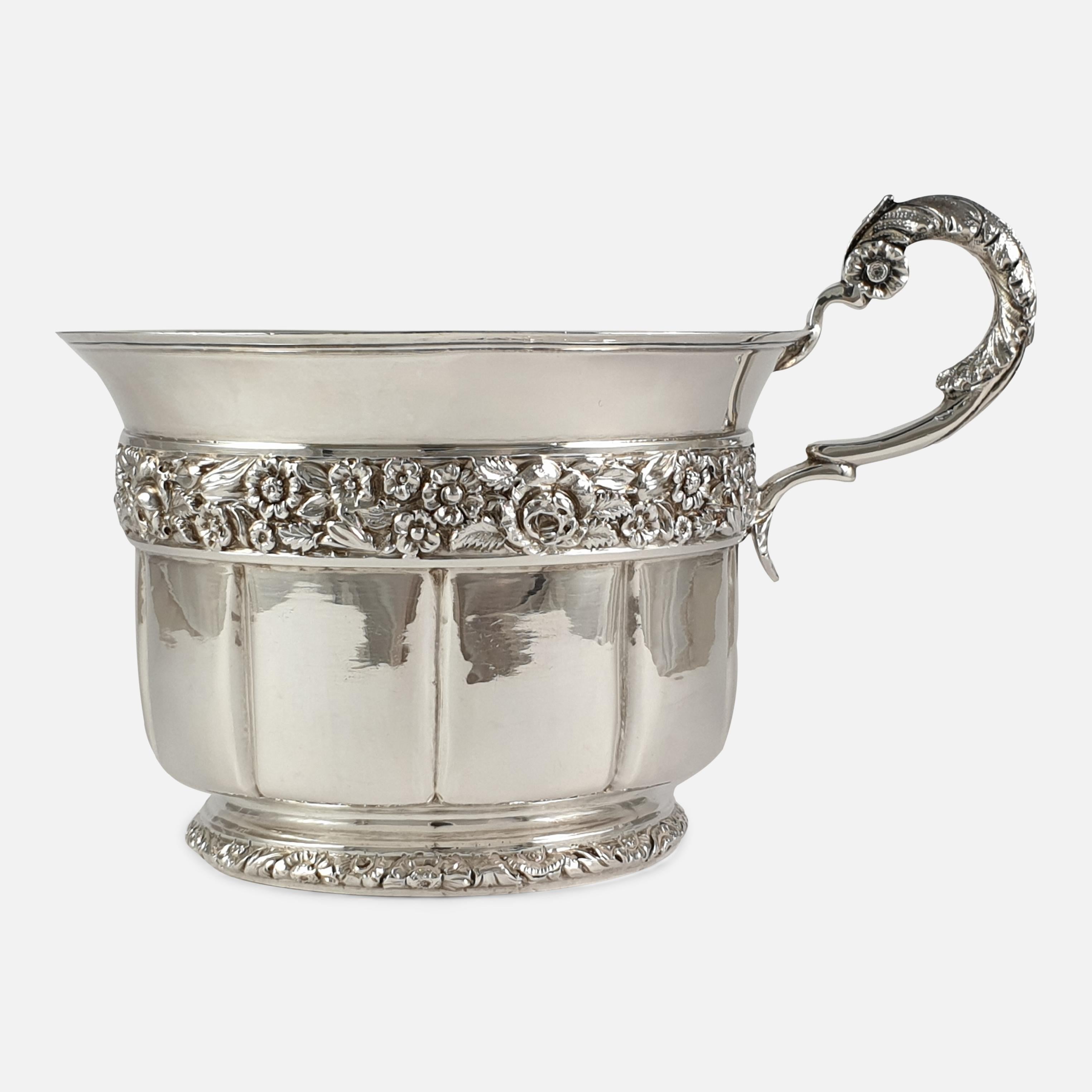 A George IV sterling silver gilt christening cup, by Charles Reily & George Storer, London, 1828. The christening cup is of circular fluted form with gilt interior; profusely decorated with flowers and leaves around the perimeter, to the scrolling