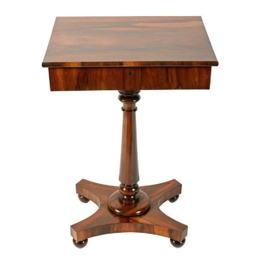An early 19th century George IV zebra wood lamp table.

The table has a slim box top with a hinged lid and veneered in zebra wood.

The platform base has four concave sides and is lifted on bun feet.

The turned tapering pillar support is made