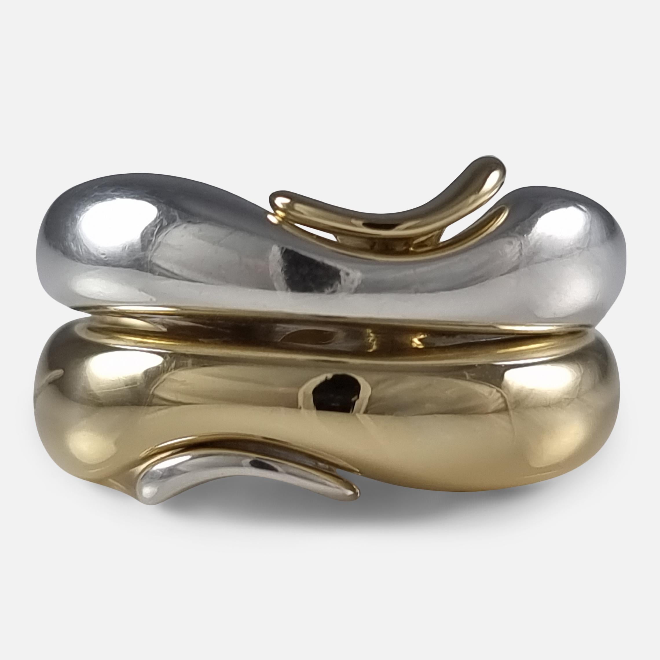 An 18 carat yellow gold and sterling silver puzzle style ring, #1345 & #345, designed by Minas Spiridis for Georg Jensen.

The two part ring is stamped with post 1945 Georg Jensen marks. 

Assay: - One of the rings is hallmarked with Edinburgh