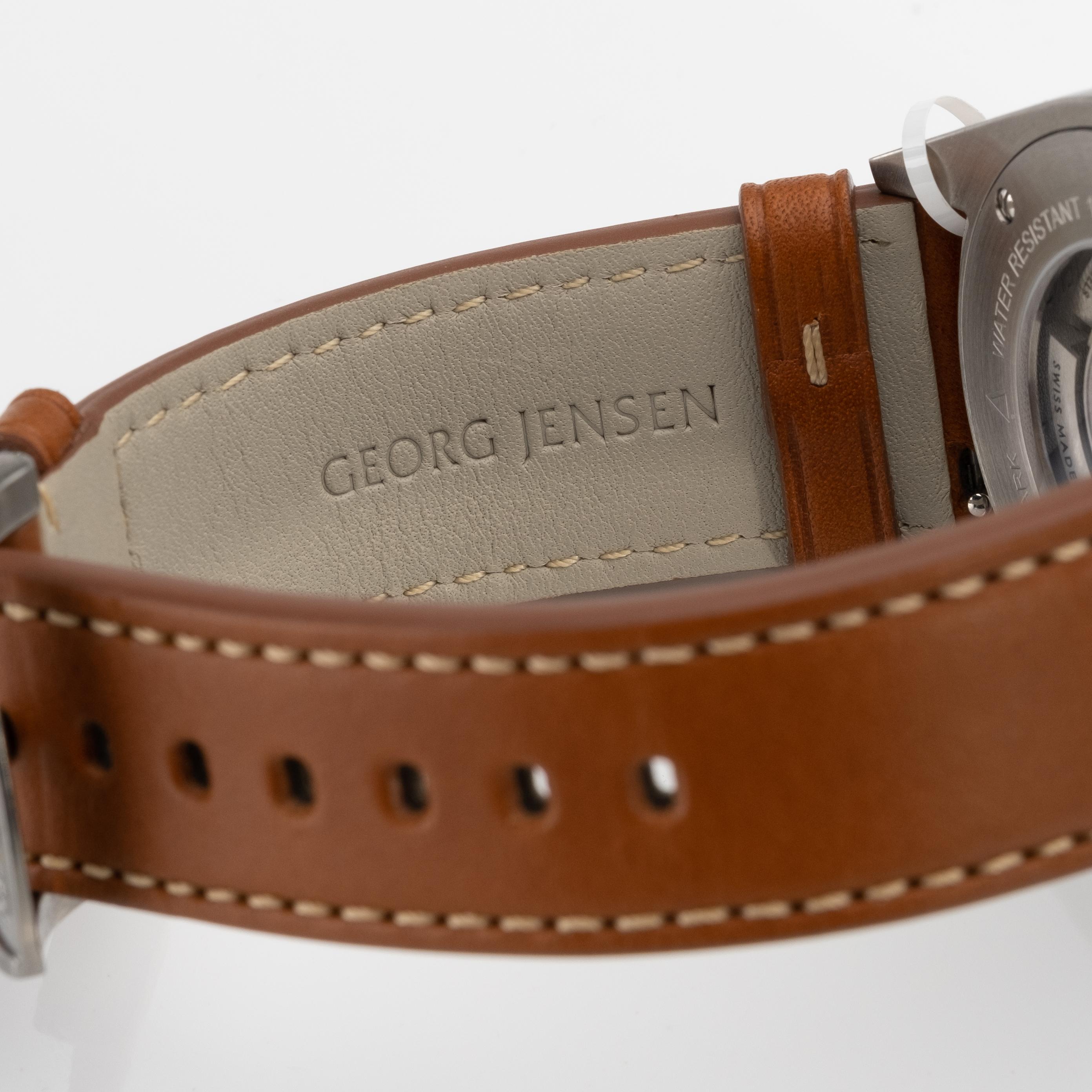 Georg Jensen Delta GMT automatic watch, featuring full size brown leather band with GJ buckle. White dial with black markers, center second hand. Working order.. Comes with box. Case 42mm. Brand New. Retails for $2650