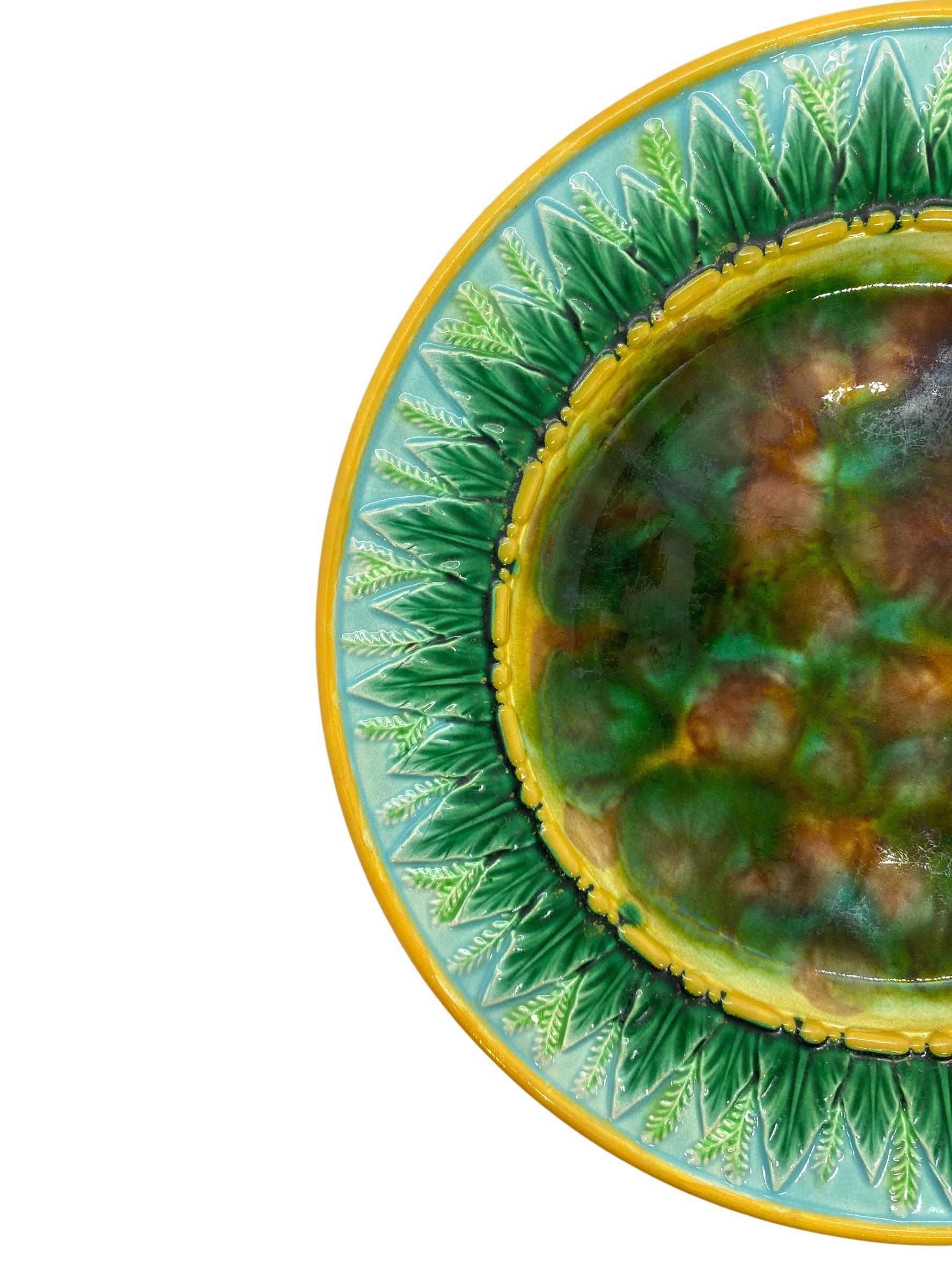 George Jones Majolica 9-in plate with mottled center, green wheat leaves and wheat stalks on turquoise, the inner and outer border glazed in yellow/ochre. The reverse with impressed 'GJ' monogram and painted pattern number '1808,' English, circa