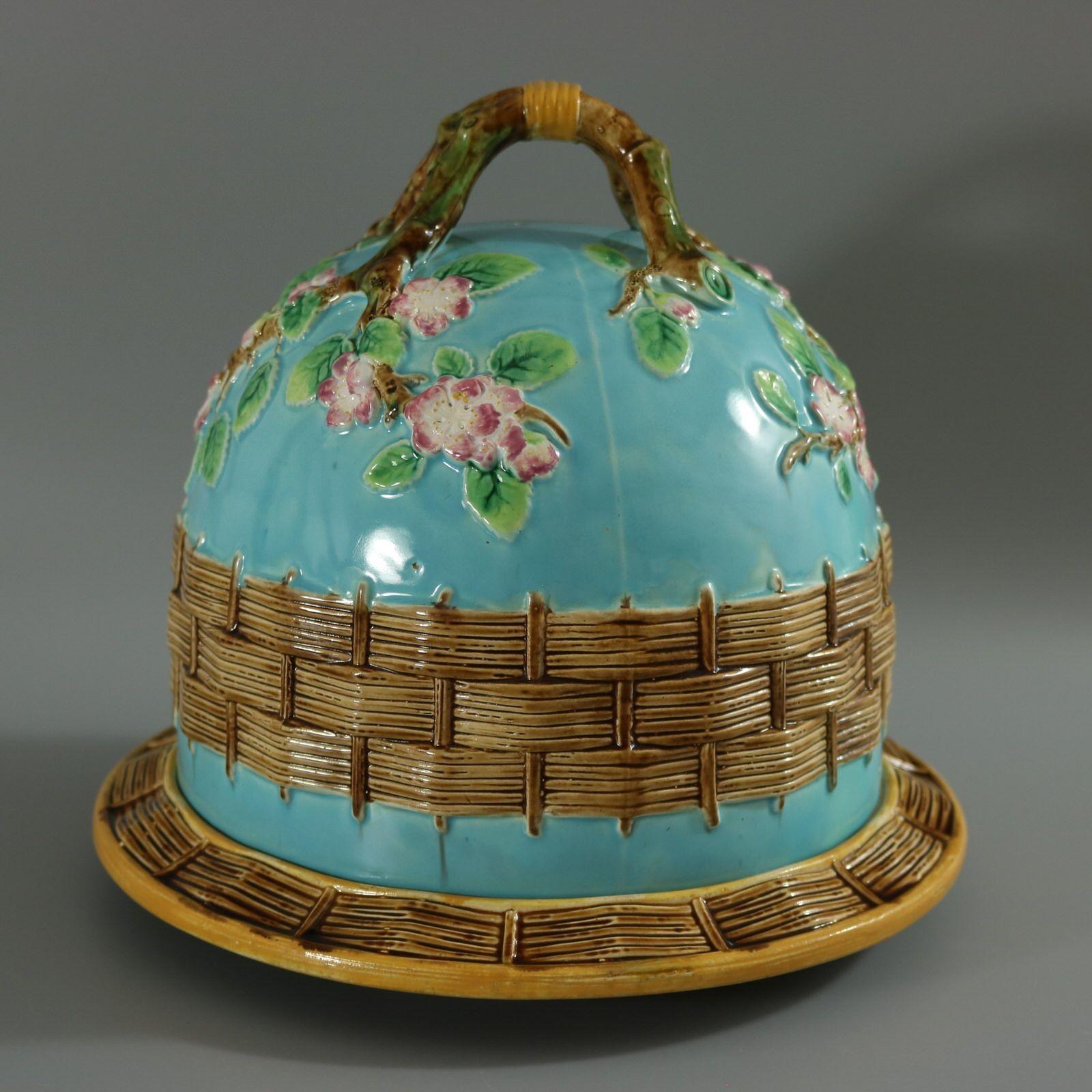 George Jones Majolica cheese keep which features a branch handle with apple blossoms. Turquoise ground version. Colouration: turquoise, brown, green, are predominant. Bears a pattern number, '3243'. English diamond registration mark for the date