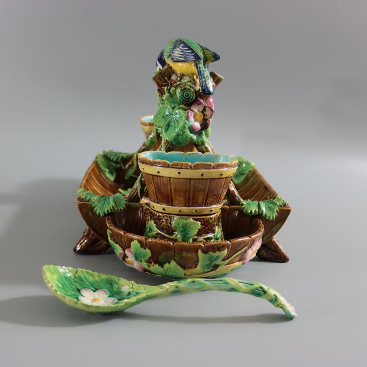 George Jones Majolica strawberry server, spoon, sugar pot and creamer which features two blue tits perched on a trestle of twigs entwined with strawberries. Removable pots. Colouration: brown, green, pink, are predominant. Bears a pattern number,