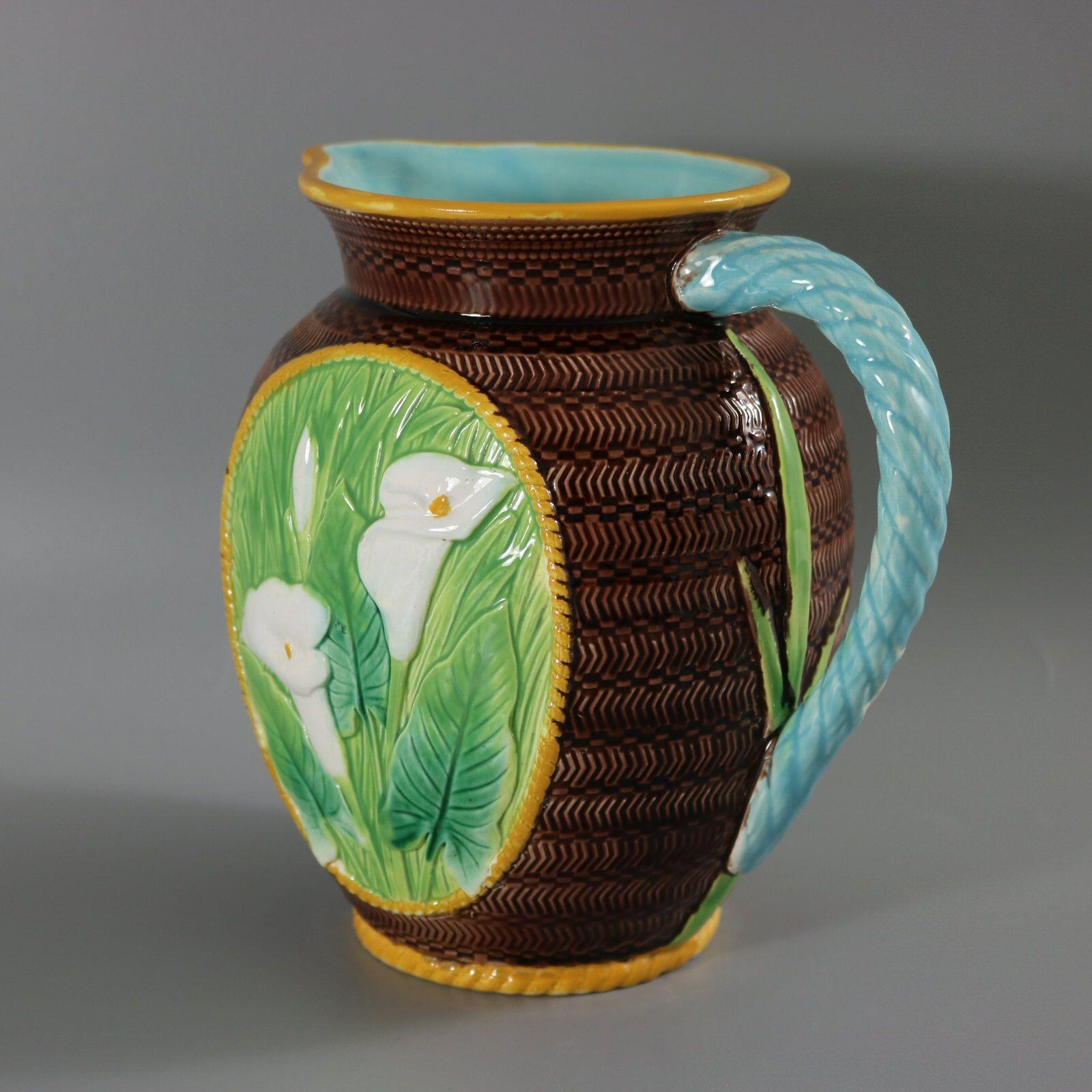 George Jones Majolica jug/pitcher which features an oval panel on either side with Calla lilies. Colouration: green, brown, white, are predominant. Bears a pattern number, '5215'.