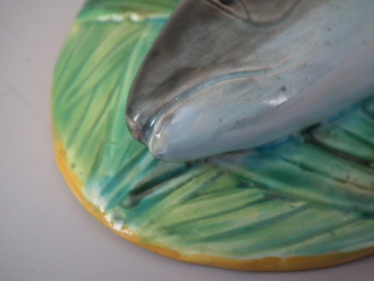 George Jones Majolika-Terrine mit Deckel, auf dem ein Makrelenfisch auf einem Bett aus Farnblättern und Schilf liegt. Färbung: gelb, grün, grau, sind vorherrschend. Das Stück trägt Herstellermarken für die Töpferei George Jones. Es trägt die