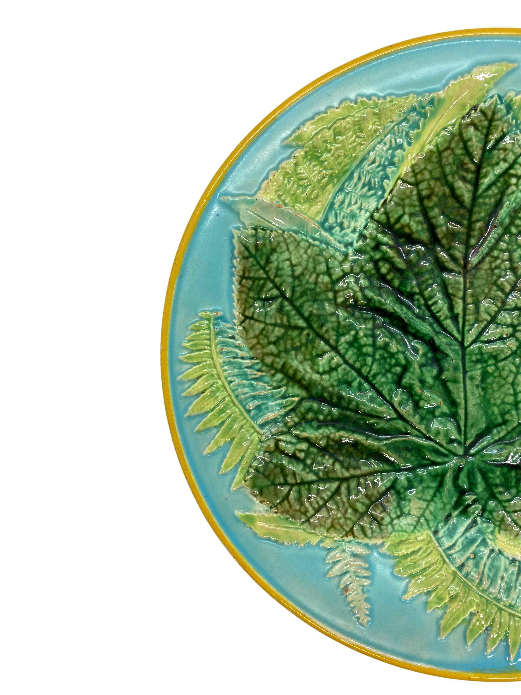 George Jones Majolica maple leaf and ferns plate on turquoise, English, ca. 1873, the relief molded dish with a central green-glazed maple leaf with Ferns on a turquoise ground, the rim banded in ochre, painted design number to reverse, '2584,'