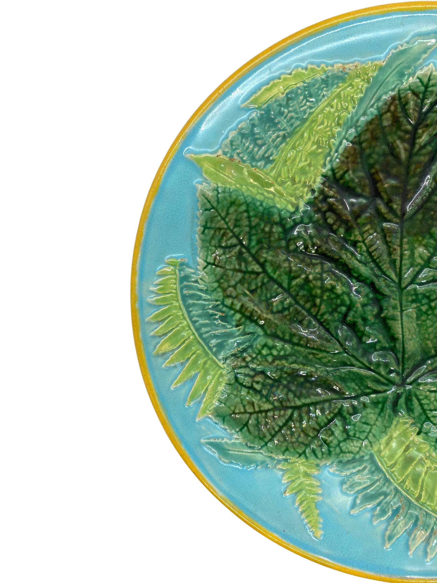 *# 2 is the one with the backrim chip*George Jones Majolica Maple Leaf and Ferns Plate on Turquoise, English, ca. 1873, the relief molded dish with a central green-glazed maple leaf with Ferns on a turquoise ground, the rim banded in ochre, painted
