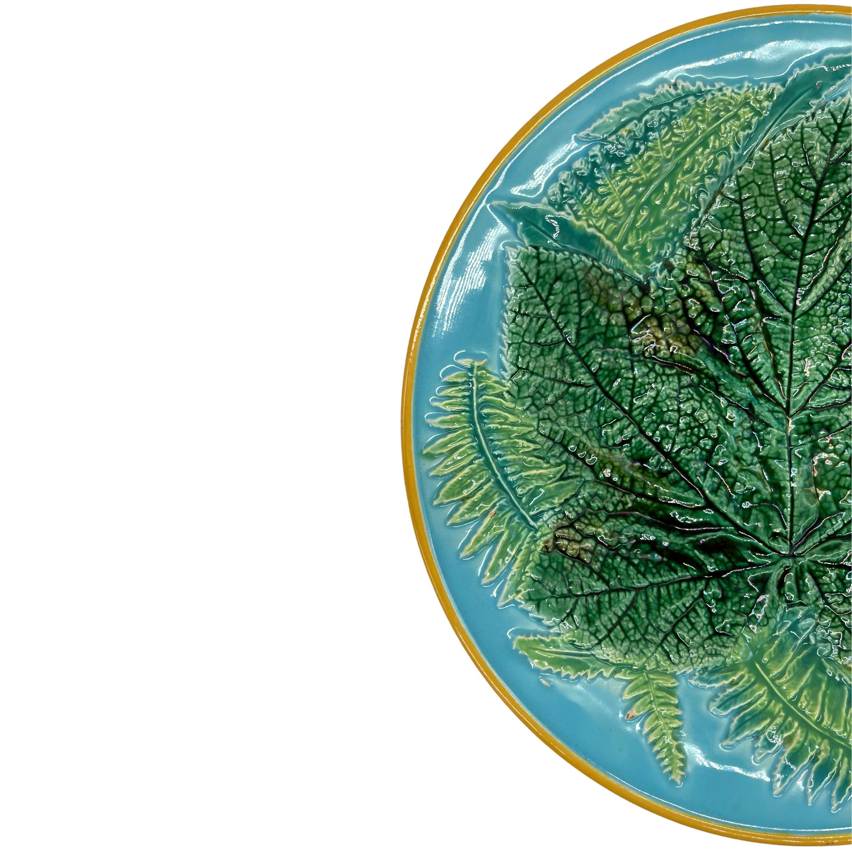 George Jones Majolica Maple Leaf and Ferns plate, English, ca. 1870, the relief molded dish with a central green-glazed maple leaf with ferns on a turquoise ground, the rim banded in yellow ocher, the reverse glazed in green and brown tortisehell