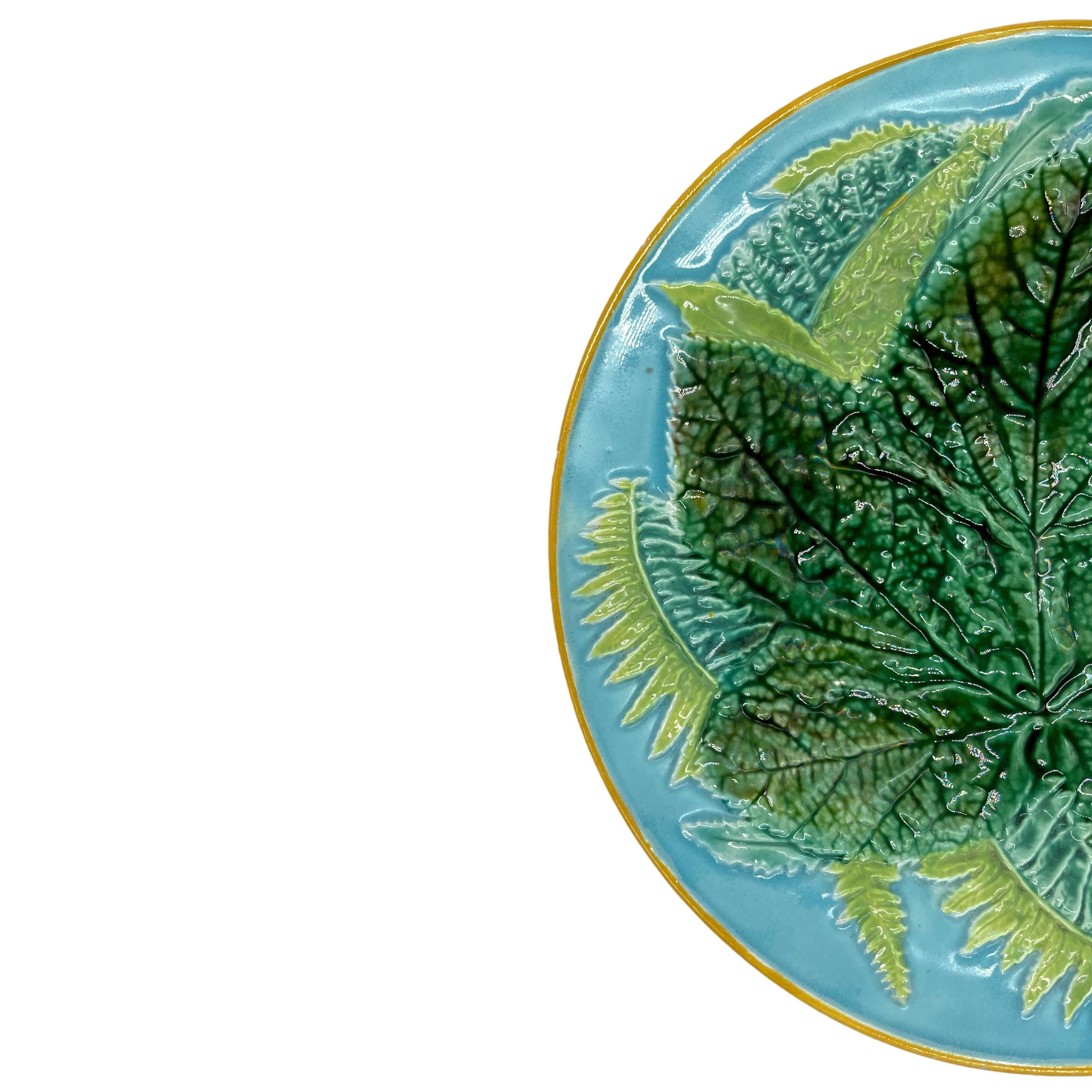 George Jones Majolica Maple Leaf and Ferns Plate, English, ca. 1870, the relief molded dish with a central green-glazed maple leaf with ferns on a turquoise ground, the rim banded in yellow ocher, the reverse glazed in green and brown tortoiseshell
