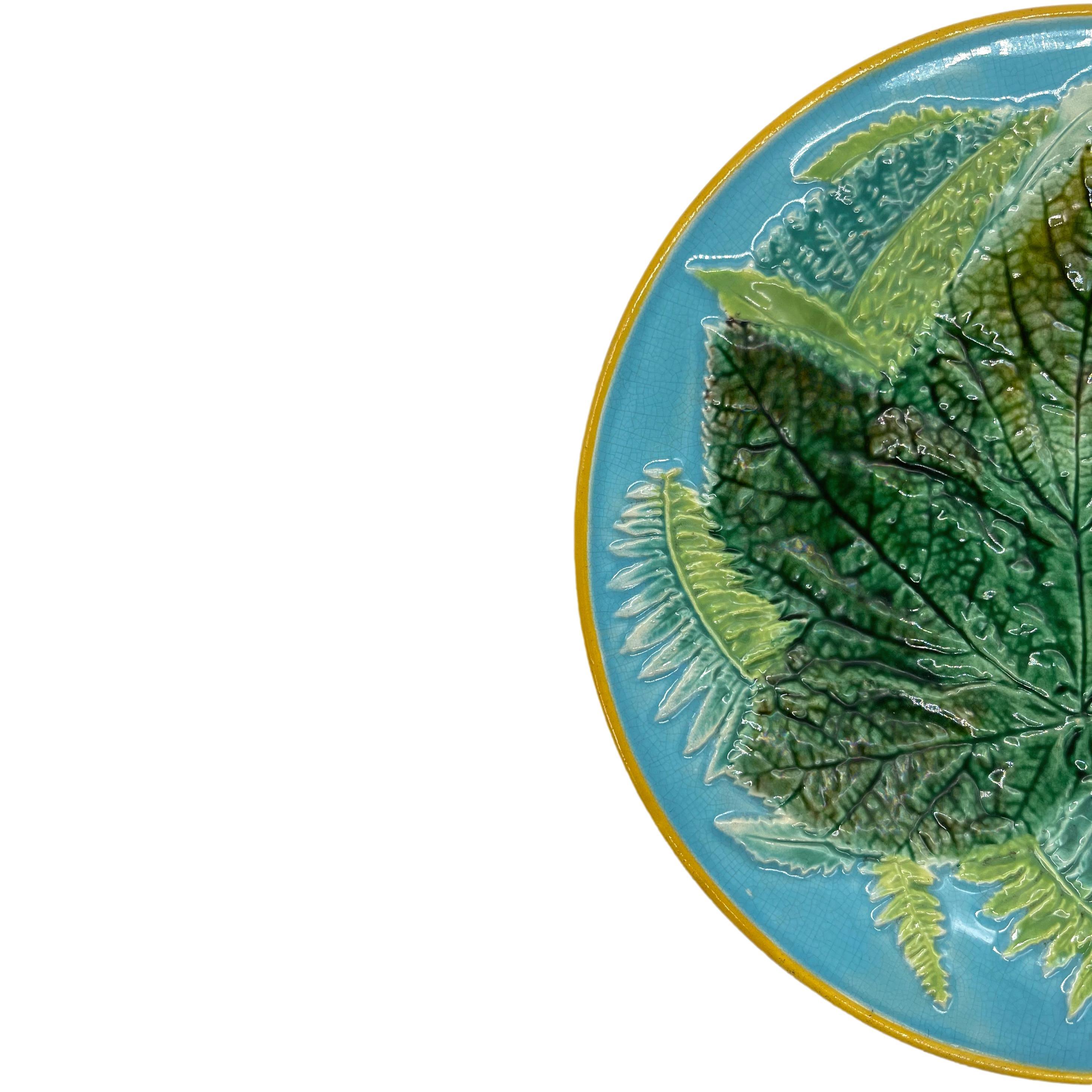 George Jones Majolica Maple Leaf and Ferns Plat, English, ca. 1873, the relief molded dish with a central green-glazed maple leaf with ferns on a turquoise ground, the rim banded in ochre, the reverse with painted design number '2584,' which