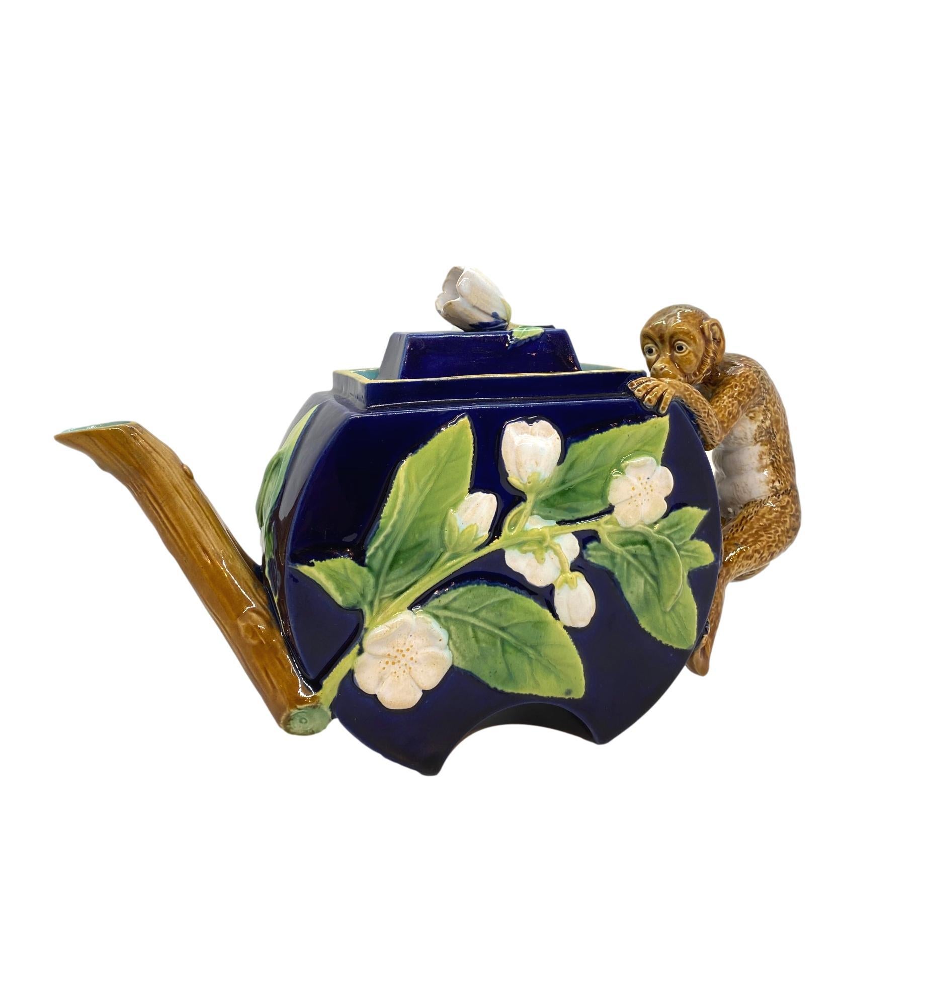George Jones majolica monkey teapot in cobalt blue, English, ca. 1875 of crescent shape, with relief molded blossoming branches, with a bud forming the knop, the handle formed by a comical monkey. 
Design number 3450; design registered: 26 June