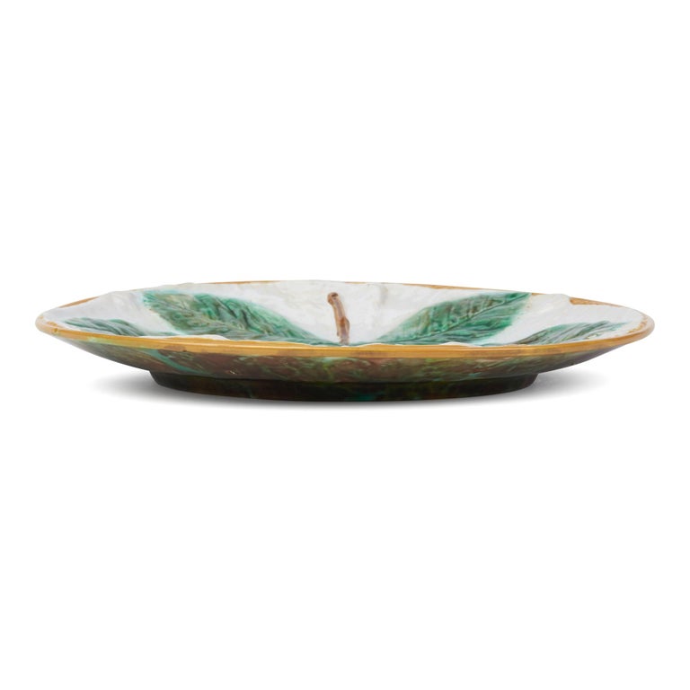 A fine antique horse chestnut leaf design majolica plate by George Jones and dating between 1861 and 1873. The rounded pottery plate is heavily moulded with the well detailed leaf painted in naturalistic green and brown colors and set against a