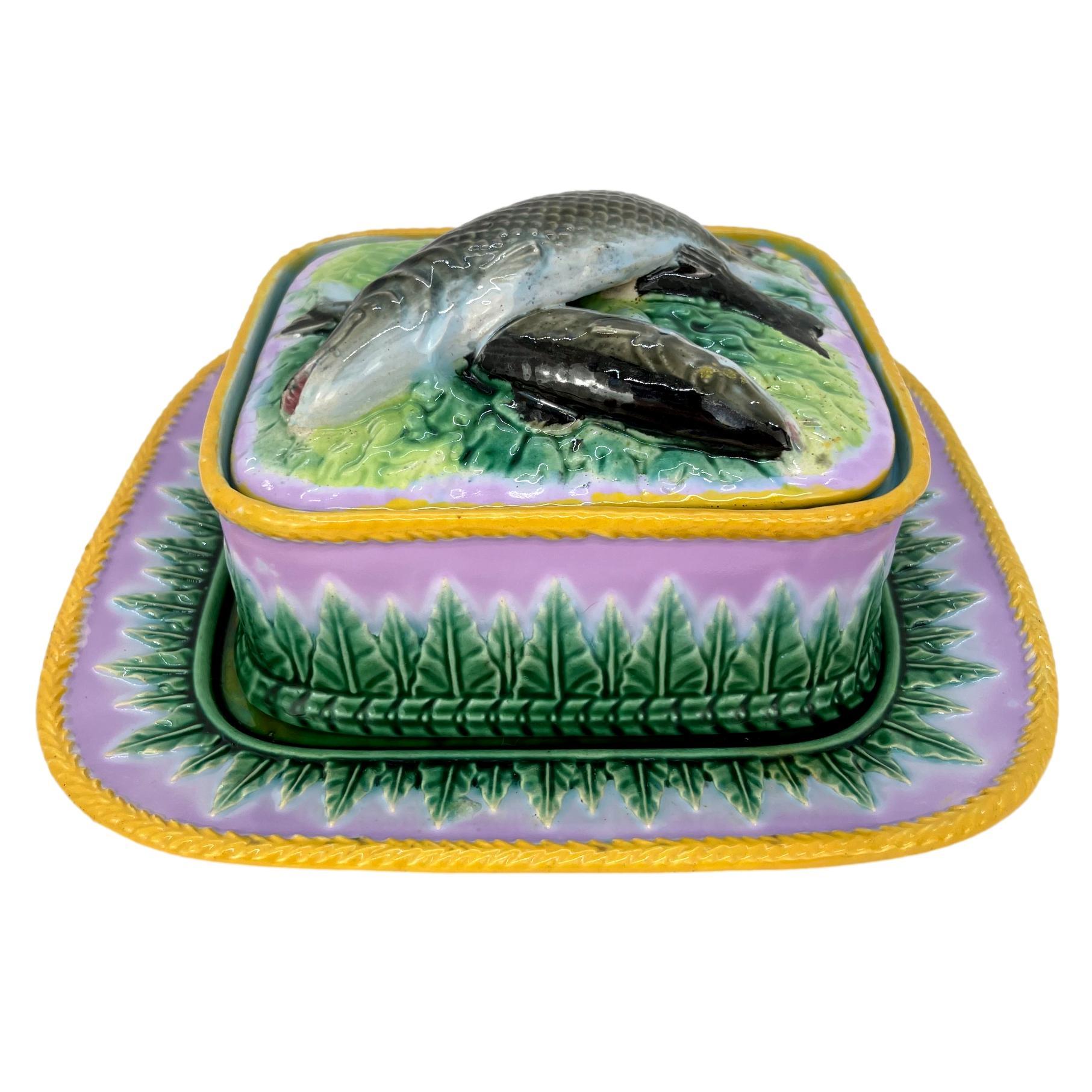 George Jones Majolica Sardine box on pink ground, English, ca. 1866, the box molded with green acanthus leaves on a pink ground, with matching underplate, the lid molded in high relief with three sardines, the top one forming the knop, with