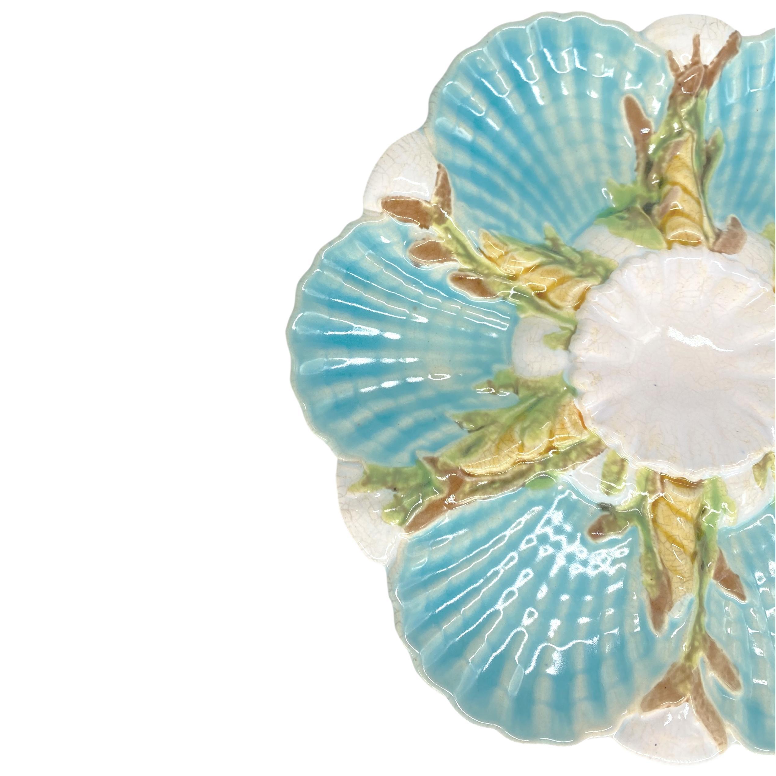 A George Jones Majolica Oyster Plate, the central well molded in high relief on a round mound of naturalistically molded and white-glazed, with six open scallop shells with fluted and scalloped wells glazed in turquoise, separated by spokes formed