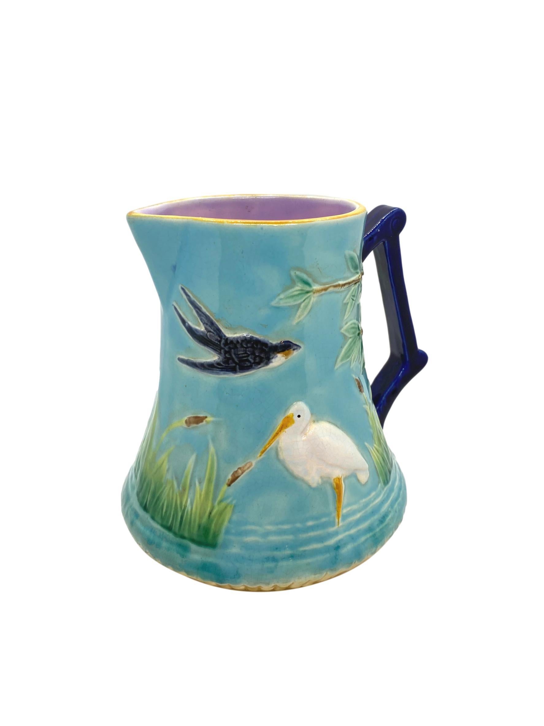George Jones Majolica Stork in Marsh Pitcher, English, ca. 1878, the relief molded body of tapering cylindrical form, with storks in simulated water among bullrushes and birds to either side, with a tree and branches issuing from under the cobalt