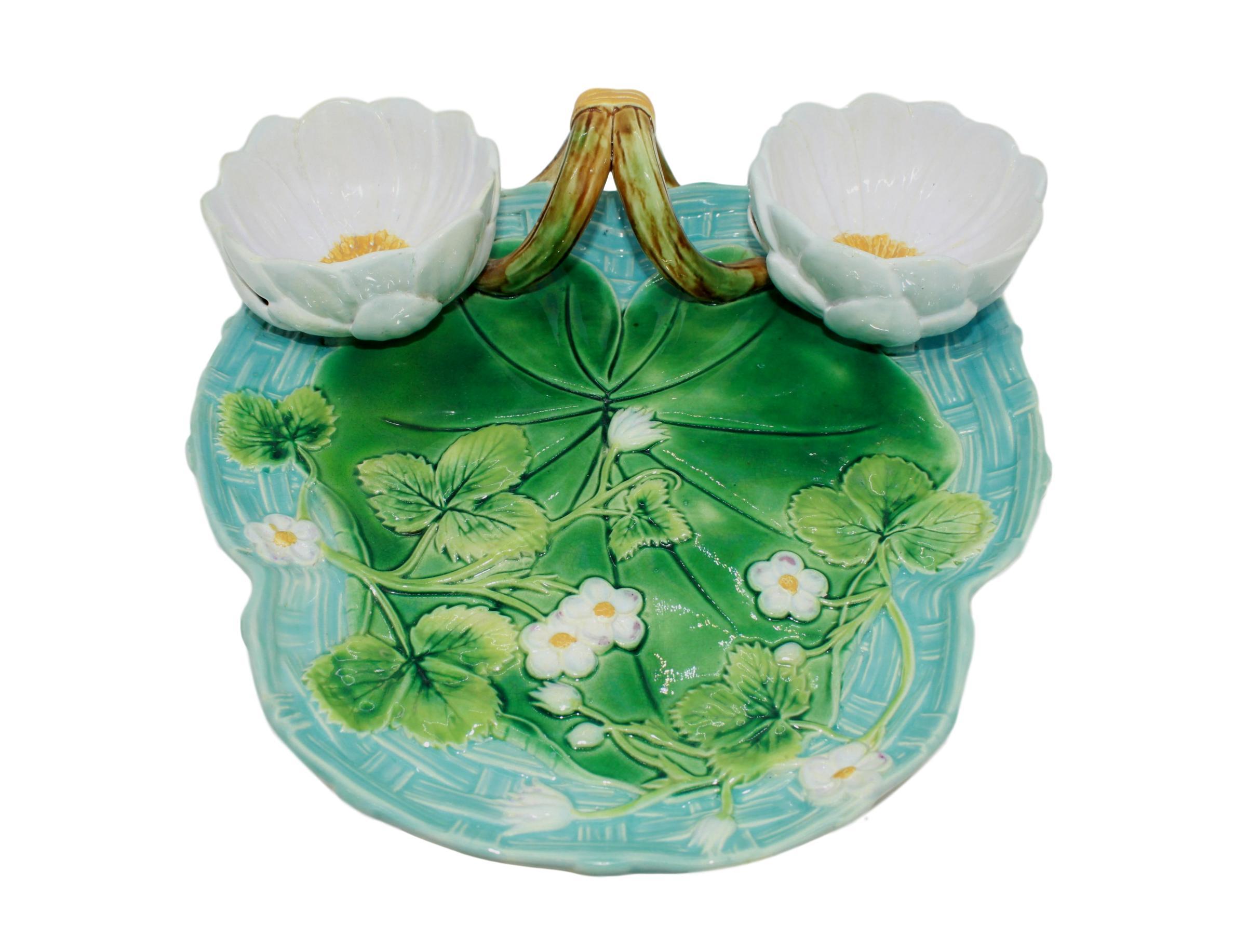 George Jones Majolica Strawberry Server, Turquoise and Green, with yellow-banded mossy twigs forming the handle, the platter with a large green-glazed lily pad and trailing strawberry leaves and blossoms, on a turquoise blue glazed basket-weave