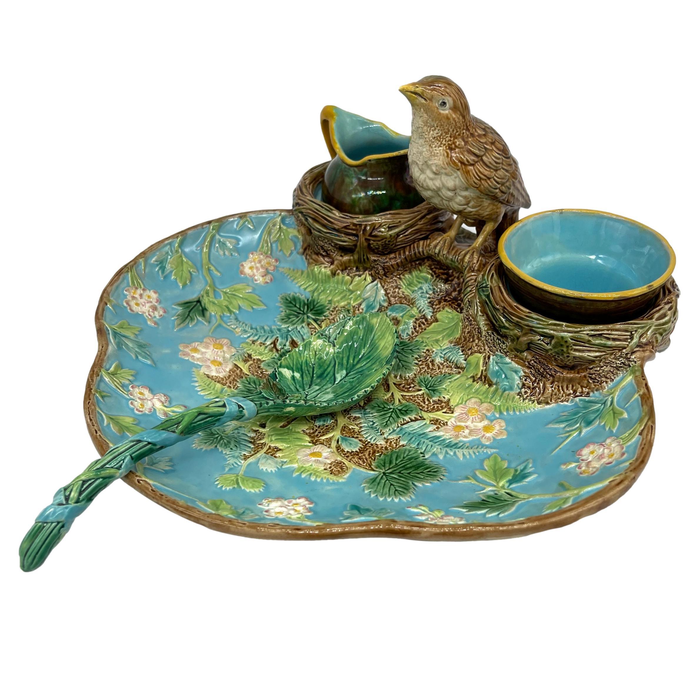 George Jones Majolica strawberry server, ca. 1870, the trefoil dish naturalistically modelled with blossoming strawberry plants and ferns on a turquoise and rustic ground, surmounted with a life-size Thrush perched on simulated branches between two