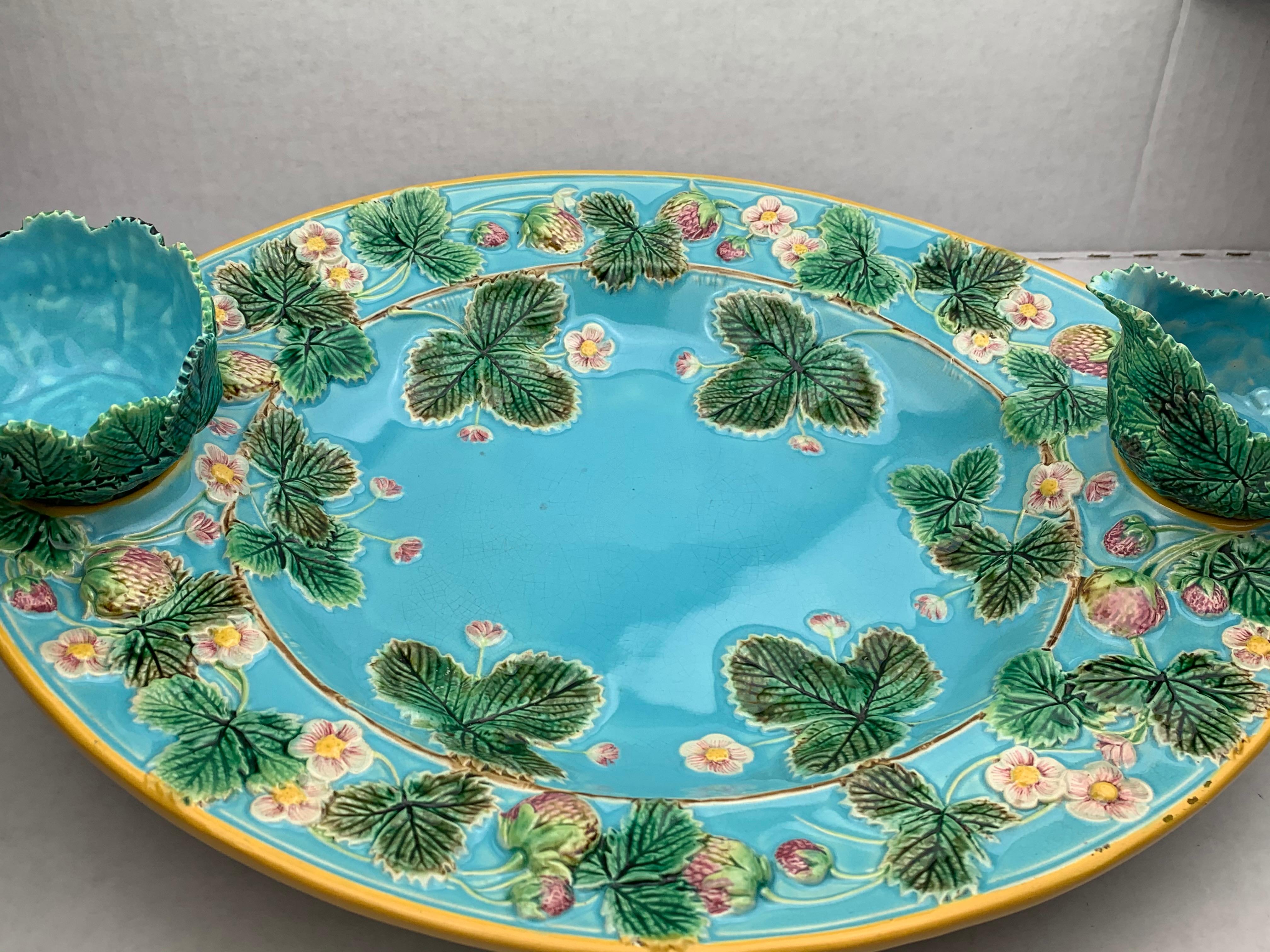 George Jones Majolica strawberry server with separate cream and sugar, English, 1879. Naturalistically molded strawberries, strawberry leaves and blossoms to the inner and outer border, the center bowl and ground glazed in deep turquoise blue, with