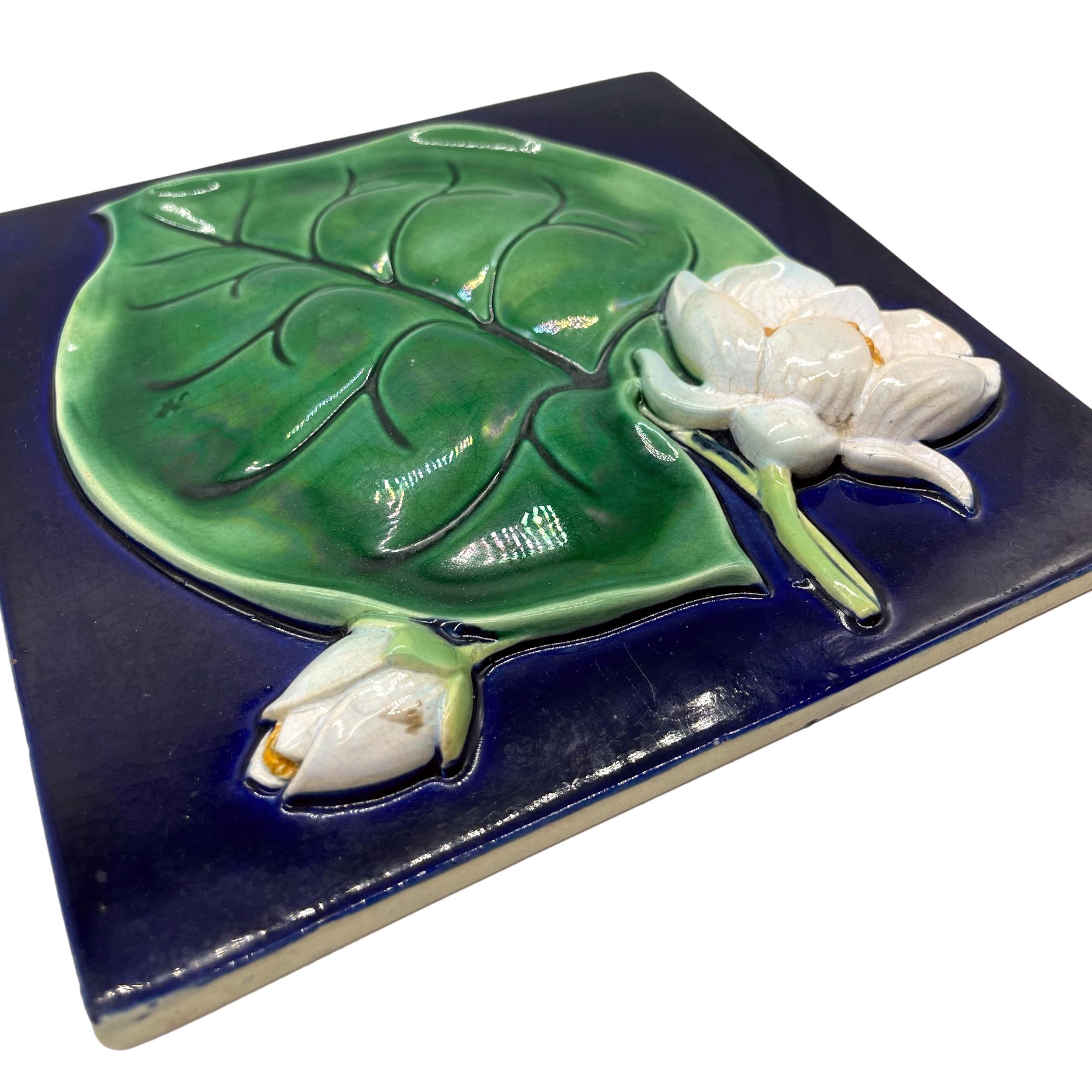 George Jones Majolica Trompe L'oeil Rare Tile, naturalistically molded in high relief with a large green-glazed lily pad and waterlilies, on a cobalt blue ground, the reverse with impressed monogram for George Jones & Sons, ca. 1880, 8.25-ins.