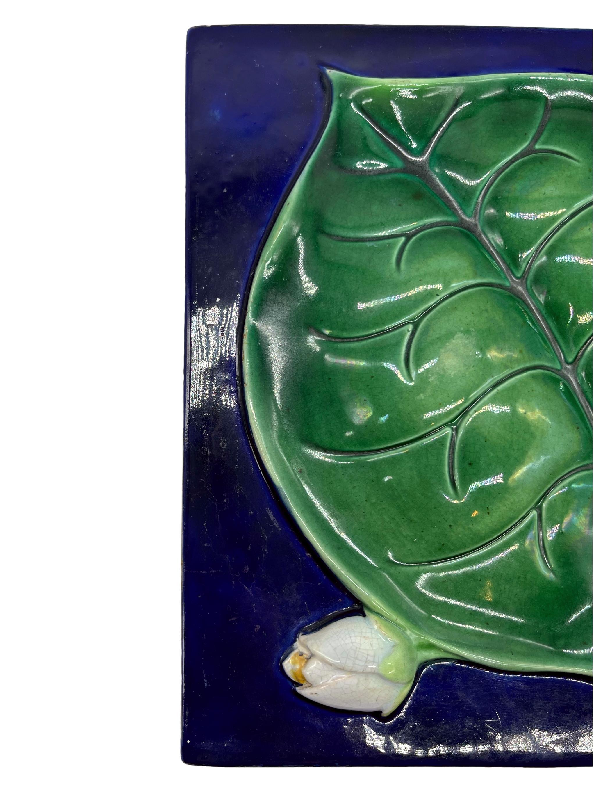 George Jones Majolica Trompe L'oeil Rare Tile, naturalistically molded in high relief with a large green-glazed lily pad and waterlilies, on a cobalt blue ground, the reverse with painted design number '3393,' ca. 1880, 8.25-ins. 
Dawes illustrates