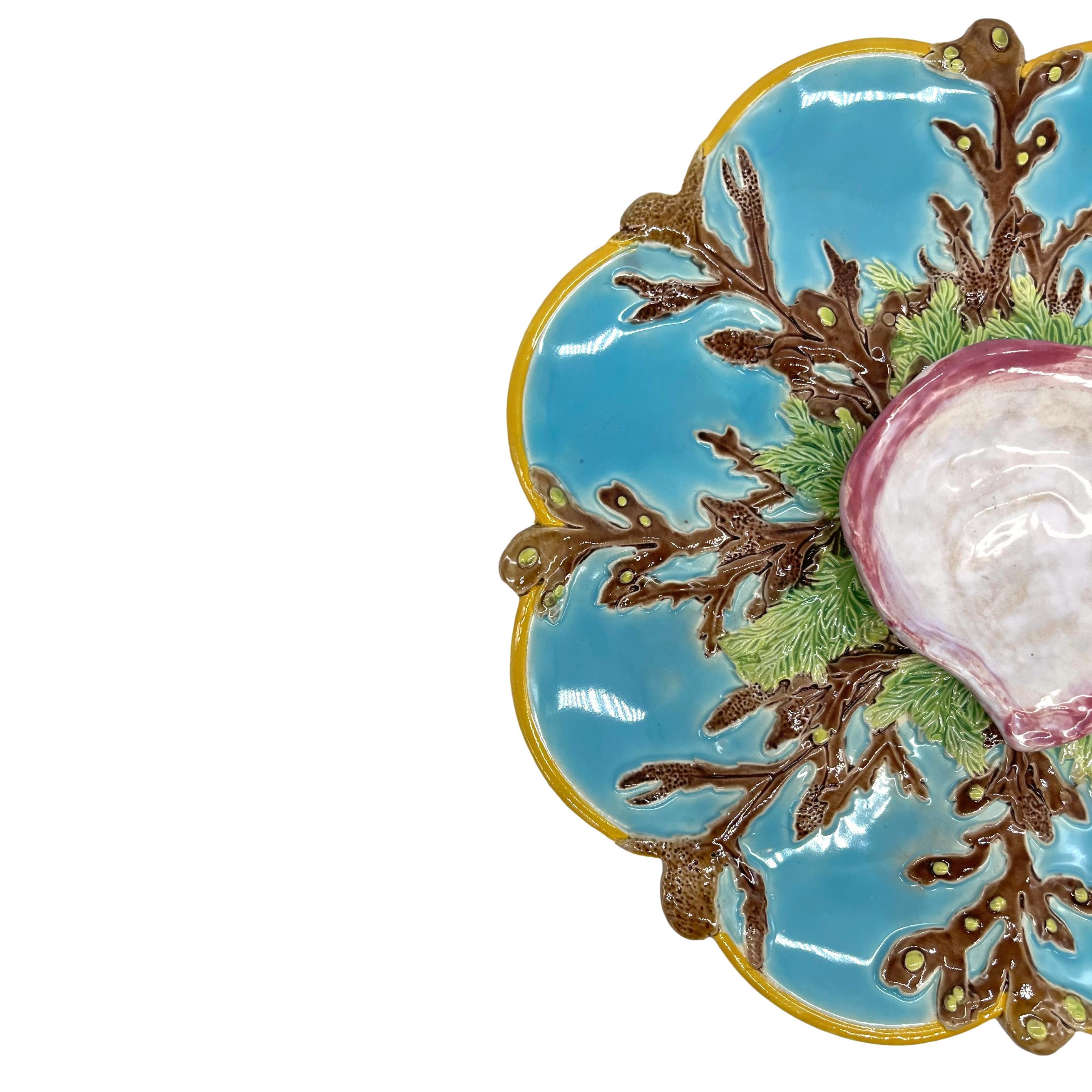 A George Jones Majolica 10-in turquoise-ground eight-well oyster server, English, ca. 1874, the turquoise wells separated by coral tentacles and seaweed, with a yellow ocher glazed border, with a raised naturalistic oyster shell glazed in white,