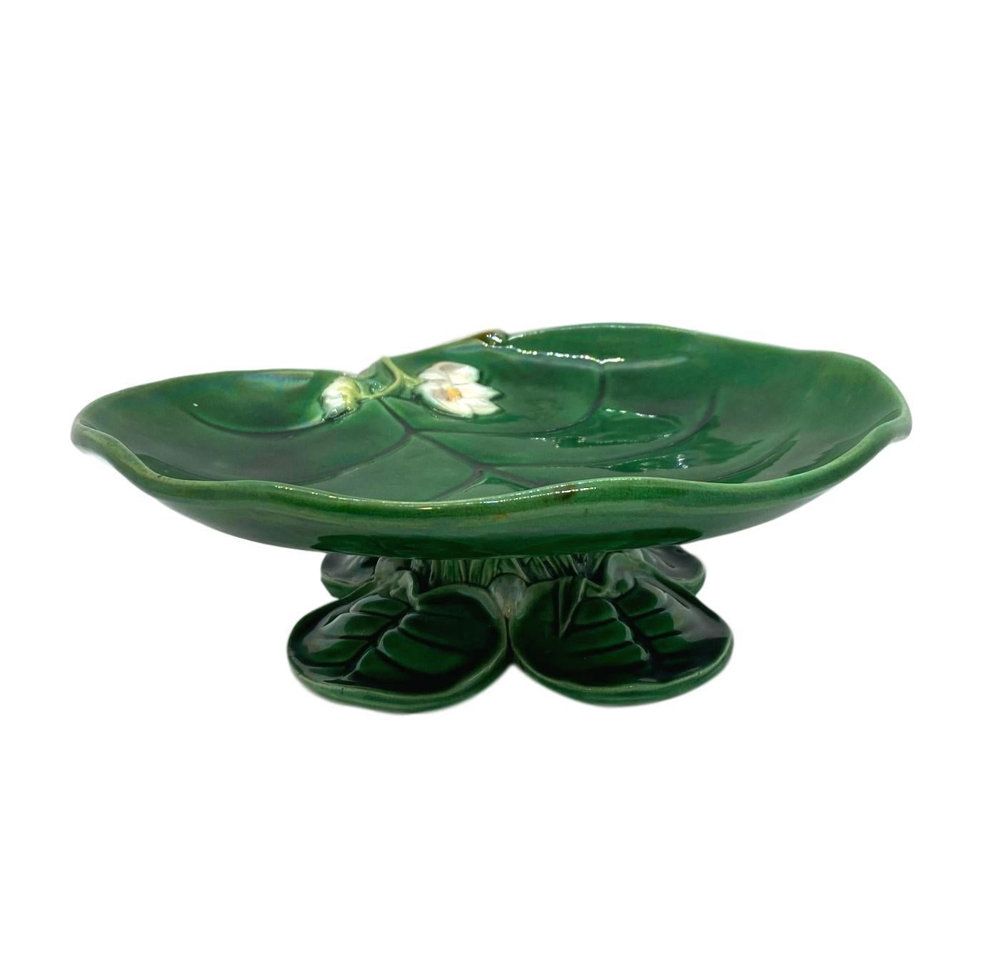 George Jones Majolica water lily footed comport glazed in lush greens, with a relief-molded lily flower, the base formed by four lily pads, English, dated 1877.
Marks to reverse: 'GJ' Monogram; British Registry Lozenge for 9 March 1869, the date