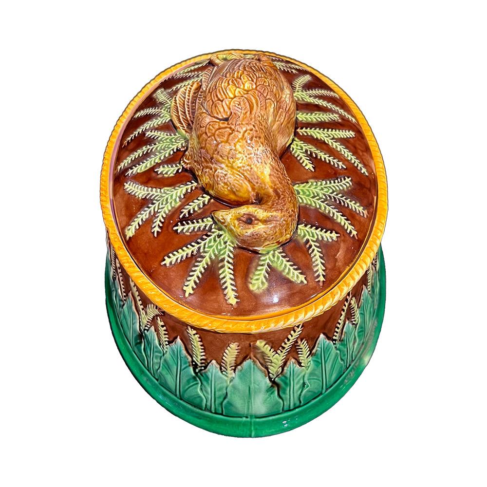 Voici la terrine en majolique de Georges Jones, datant du XIXe siècle, qui incarne à merveille l'élégance victorienne. Fabriquée avec une attention méticuleuse aux détails, cette terrine arbore des couleurs riches et un décor en relief complexe,