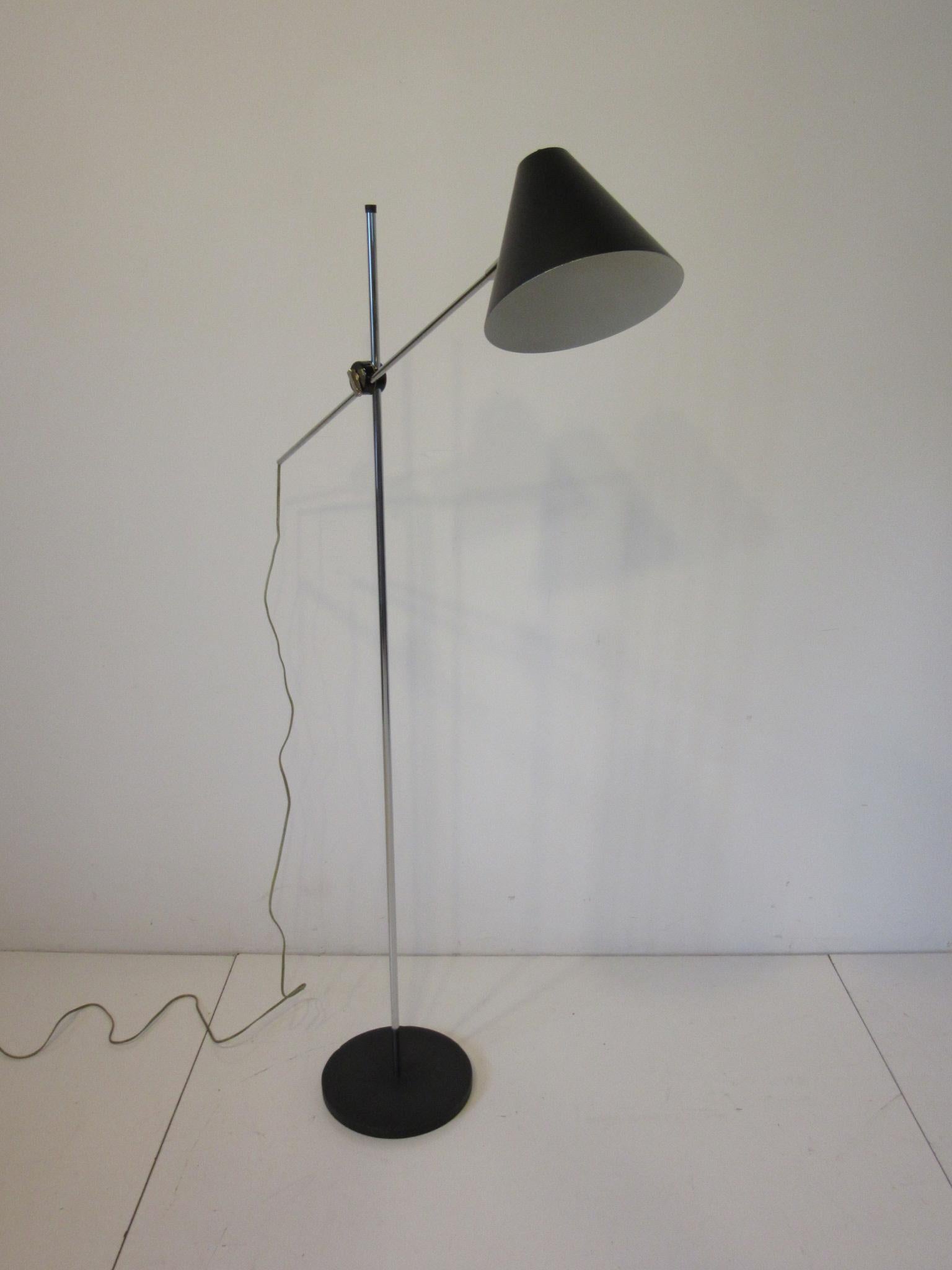 A chrome and satin black cone lamp with adjustable shade height and tilting designed and manufactured by the George Kovacs Lighting company.