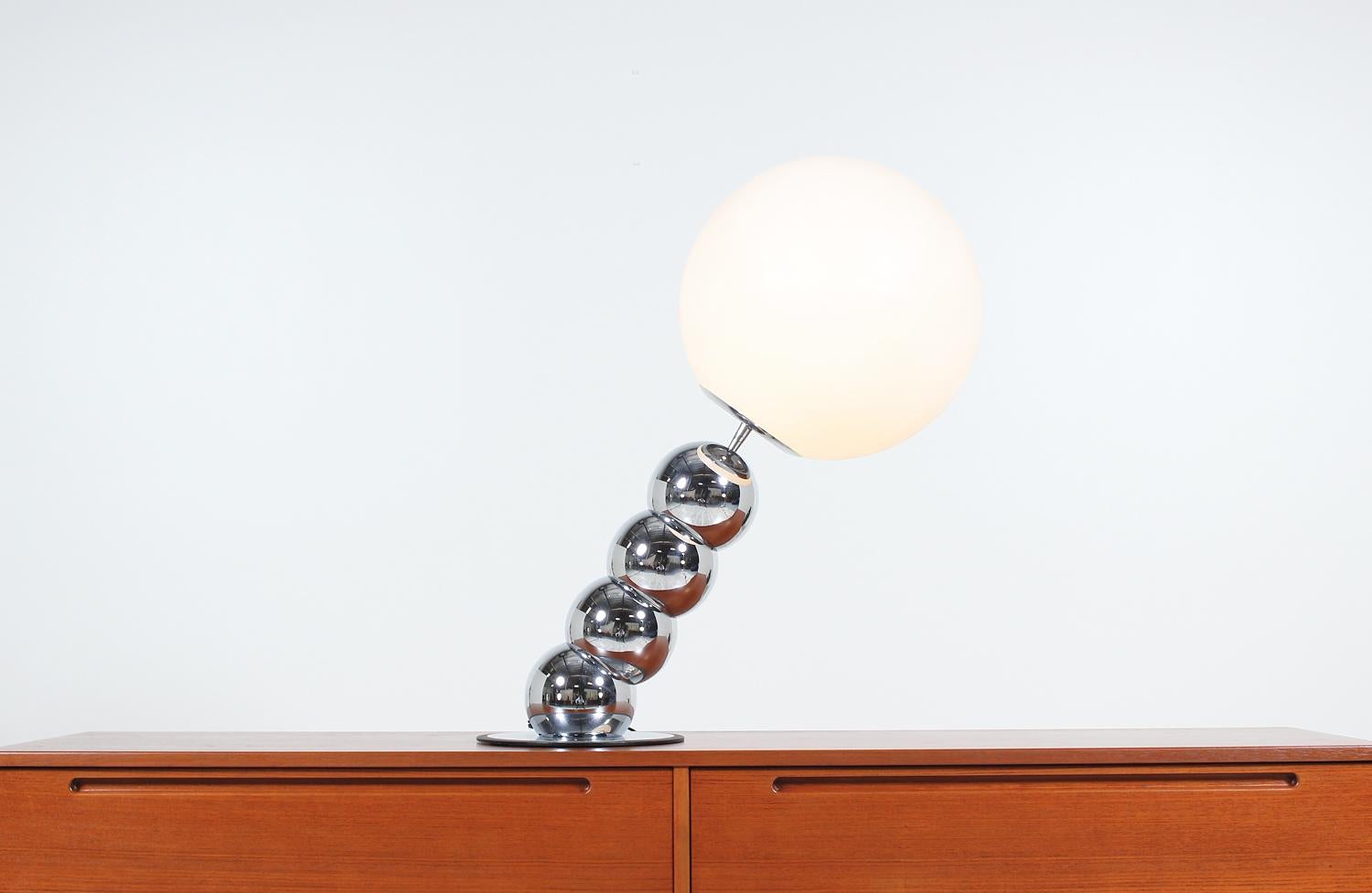 Amazing orb table lamp designed and manufactured by George Kovacs in the United States, circa 1970s. This unique lamp features four spheres that comprise the body, which are connected and slant. Set in chrome, the body supports the plastic orb shade