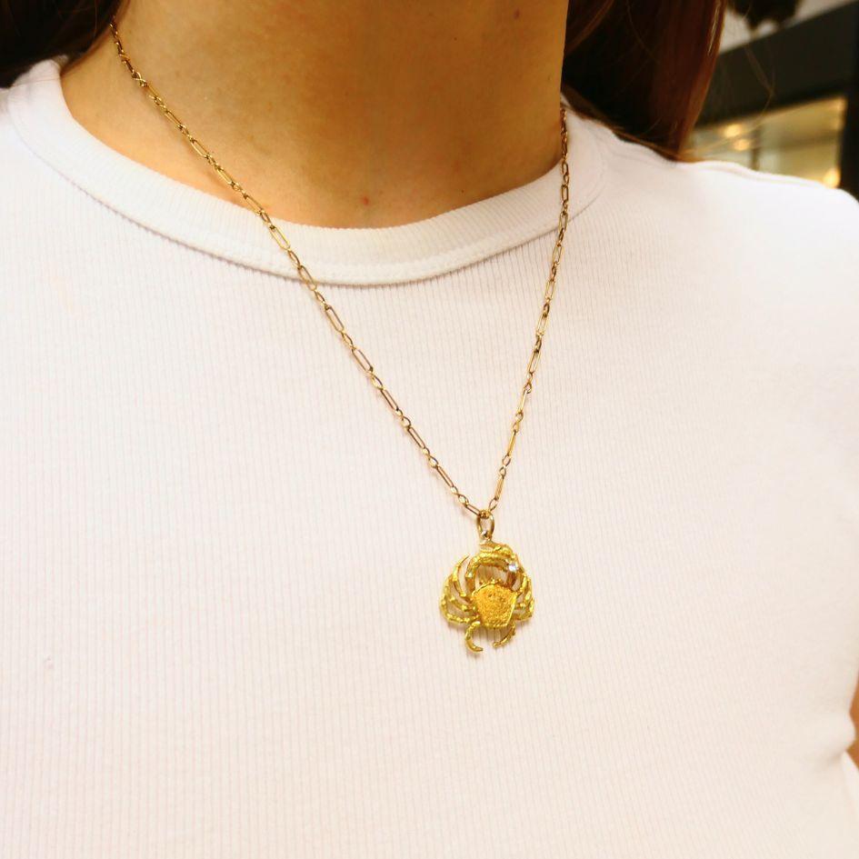 Ce collier de la fin du XXe siècle de George Lederman de New York présente un pendentif sculptural en forme de crabe, finement travaillé en or jaune 18k. Le crabe tient un seul diamant rond brillant dans une griffe surélevée, ajoutant un point focal
