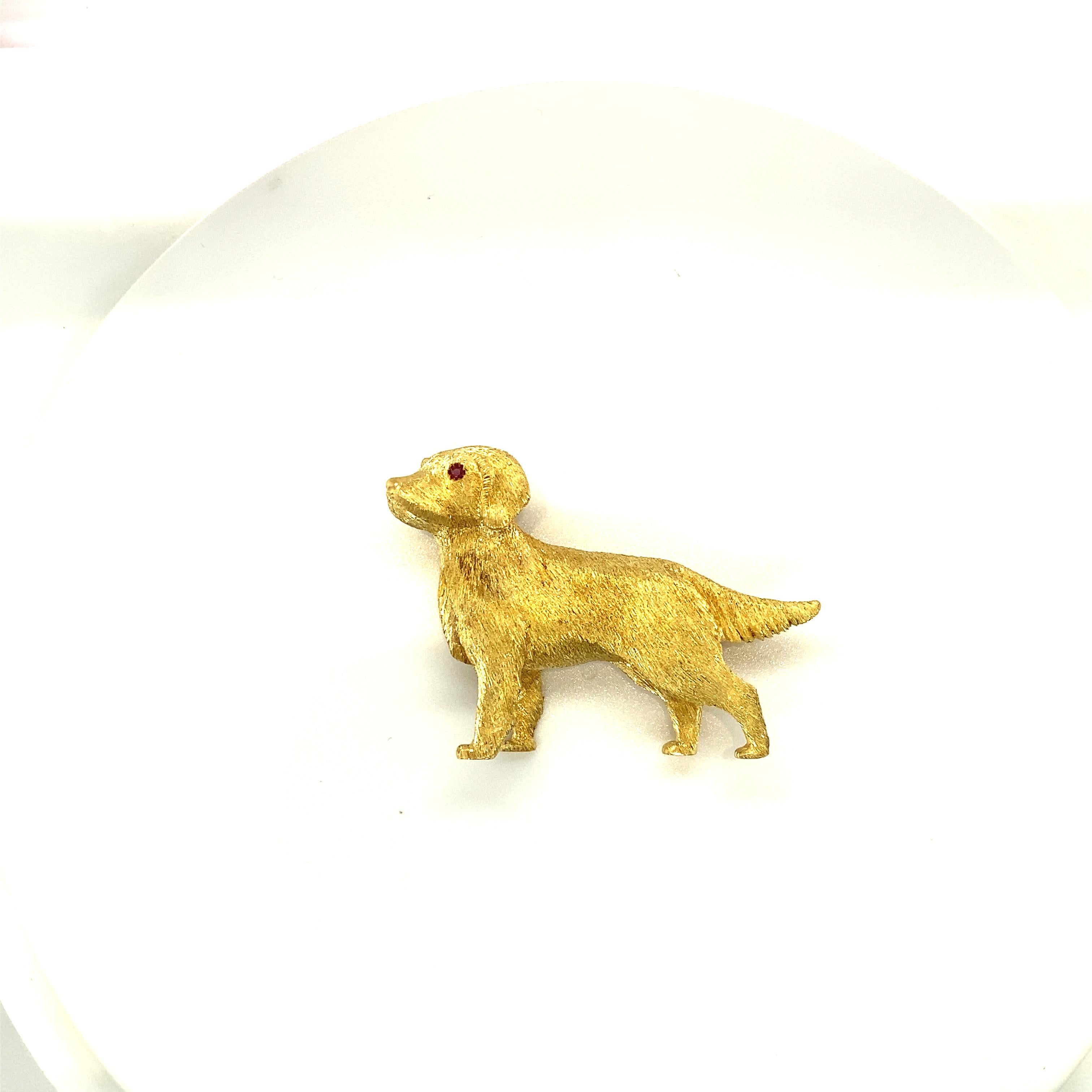 This 18 karat yellow gold Labrador Retrieverbrooch is crafted in an etched satin finish. The pup's eyes are set with round brilliant rubies. The brooch measures 2