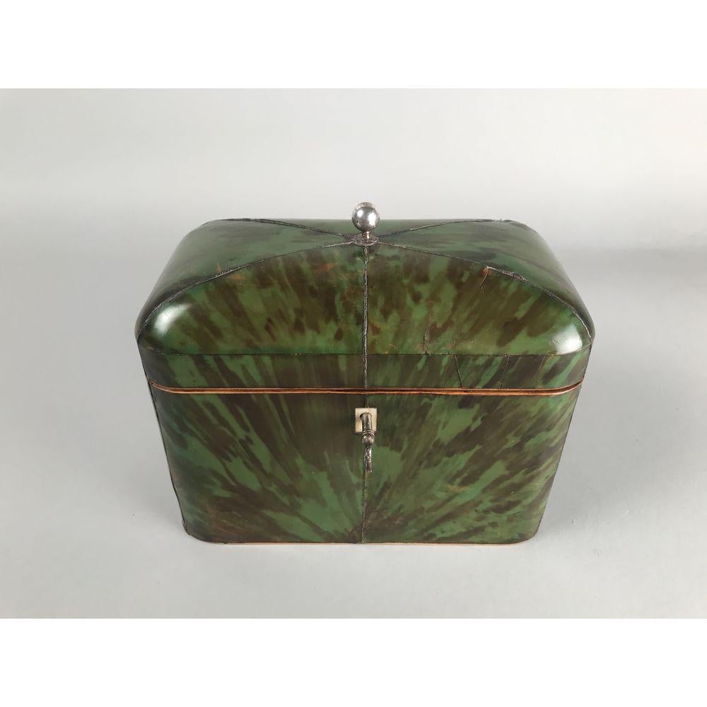 A rare George III period green tortoiseshell tea caddy of domed rectangular form, surmounted by a silver finial, circa 1800. Regency period.

Enclosing two lidded compartments with turned bone handles.
All carefully ‘bookmarked’ veneers of a