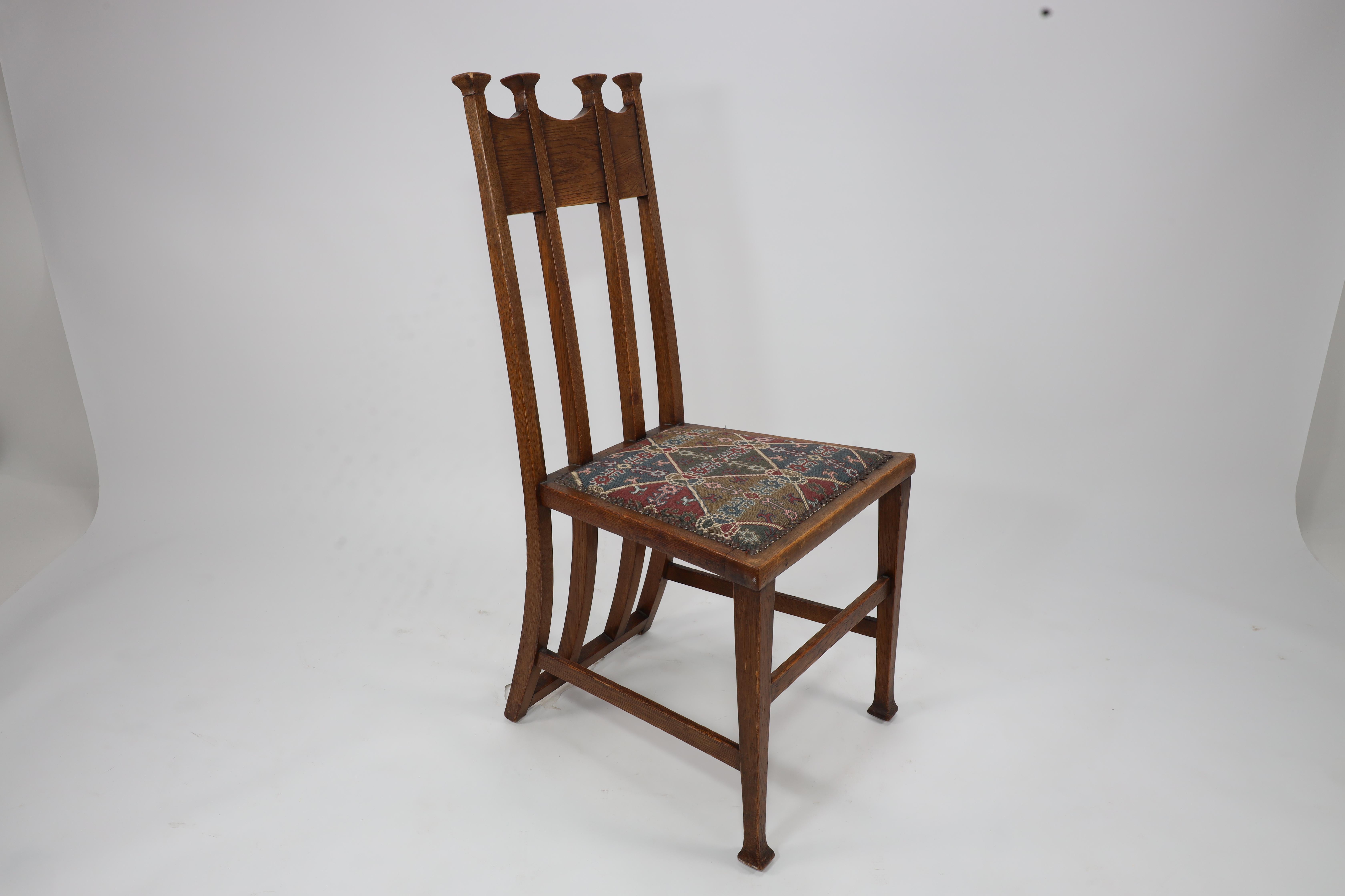 George Montague Ellwood. Made by J S Henry.
A rare set of eight Arts and Crafts oak dining chairs and two armchairs with throne like capped tops and wonderful full sweeping back supports, with tactile knops to the curvacious arms on slender opposite