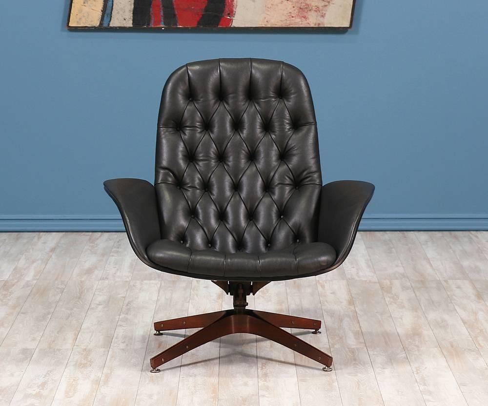 Swivel lounge chair designed in the United States by George Mulhauser for Plycraft. Deemed “Mr. Chair”, this swivel lounge chair features a newly refinished bentwood walnut shell with winged armrests and an x-base. It swivels smoothly and reclines