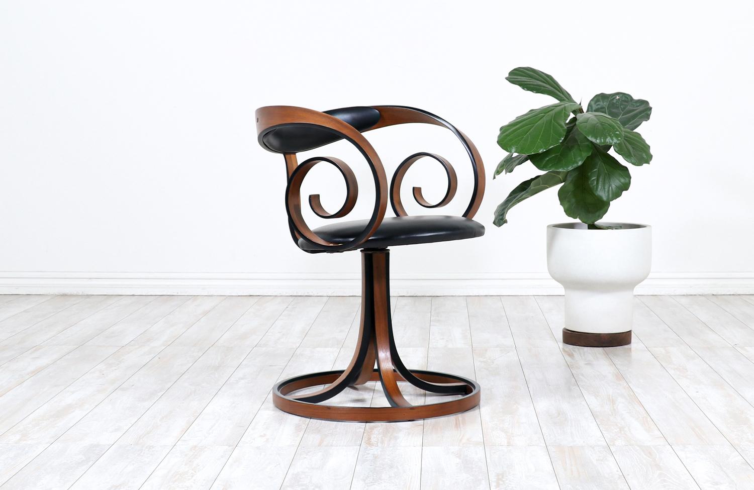 Rare armchair designed by George Mulhauser for Plycraft Co. in the United States circa 1950s. This extraordinary swivel chair has been sturdily constructed with laminated walnut bentwood visible in the organic contours and definitive lines showing