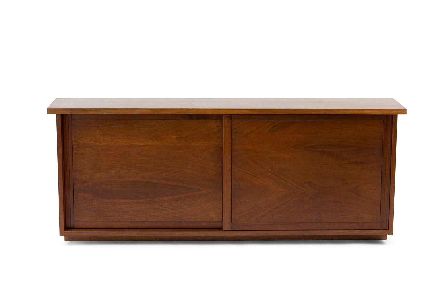 Documented studio crafted walnut credenza or sideboard by George Nakashima from 1959. This stunning example has a beautifully tapered top and sides and two sliding doors. Could be wall-mounted as well.