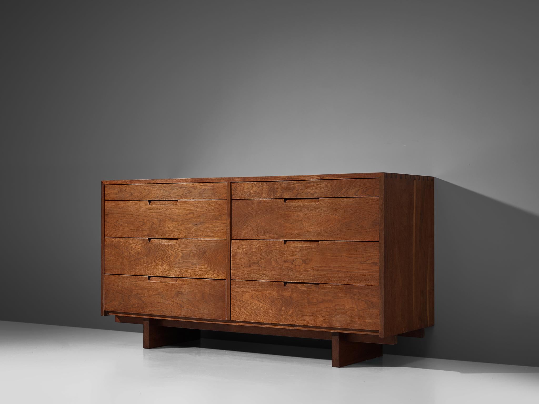 George Nakashima, cabinet in walnut, New Hope, PA, 1955.

These sideboards feature eight drawers, executed in walnut and finished with archetypical dovetail Nakashima wood-joints. The cabinets rest on two slabs of solid walnut that are placed on