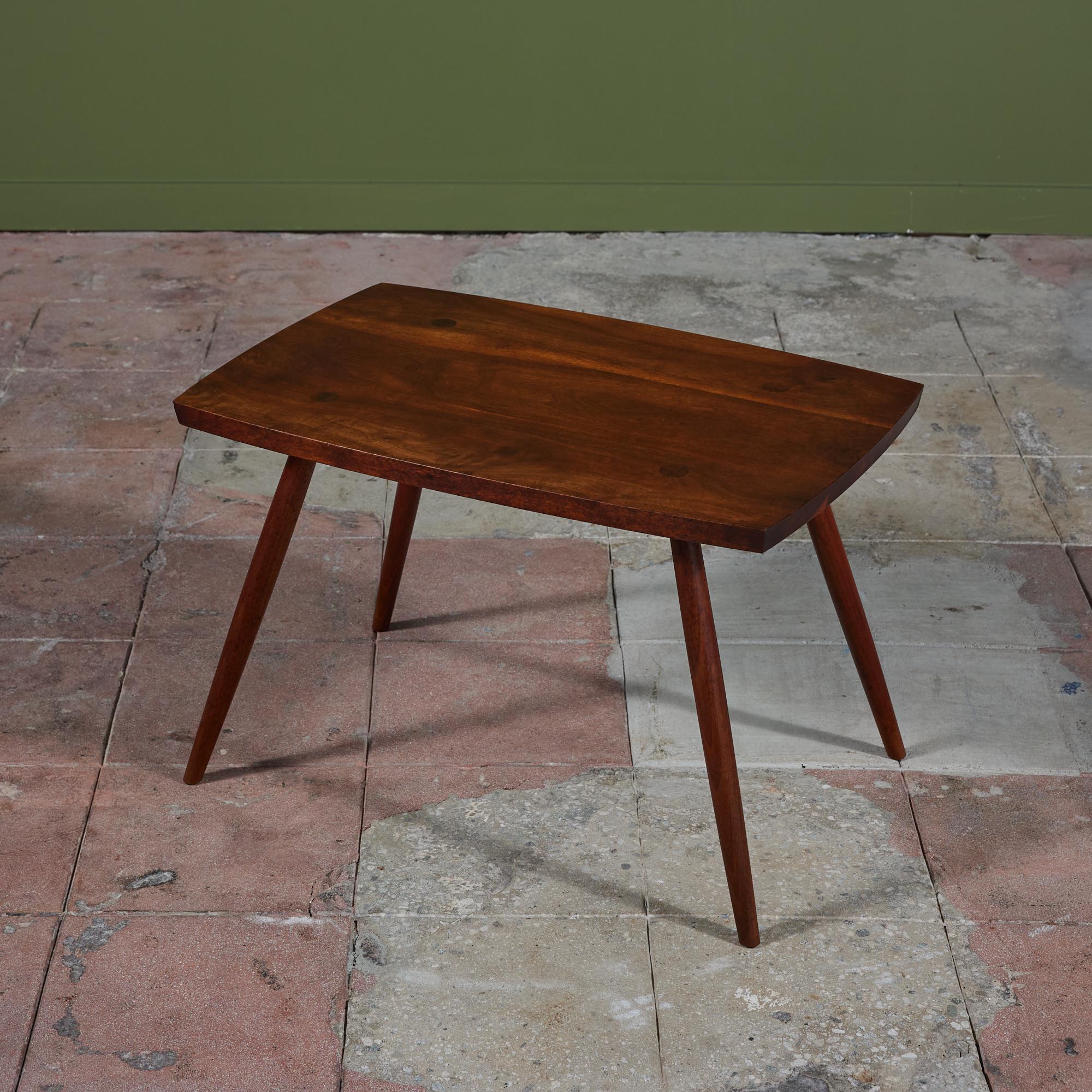 Black walnut side table from the New Hope, Pennsylvania Studio of George Nakashima. The rectangular table is minimal in design and features long tapered legs.

Dimensions:
29” width x 19” depth x 18.5” height

Condition:
Good vintage condition;