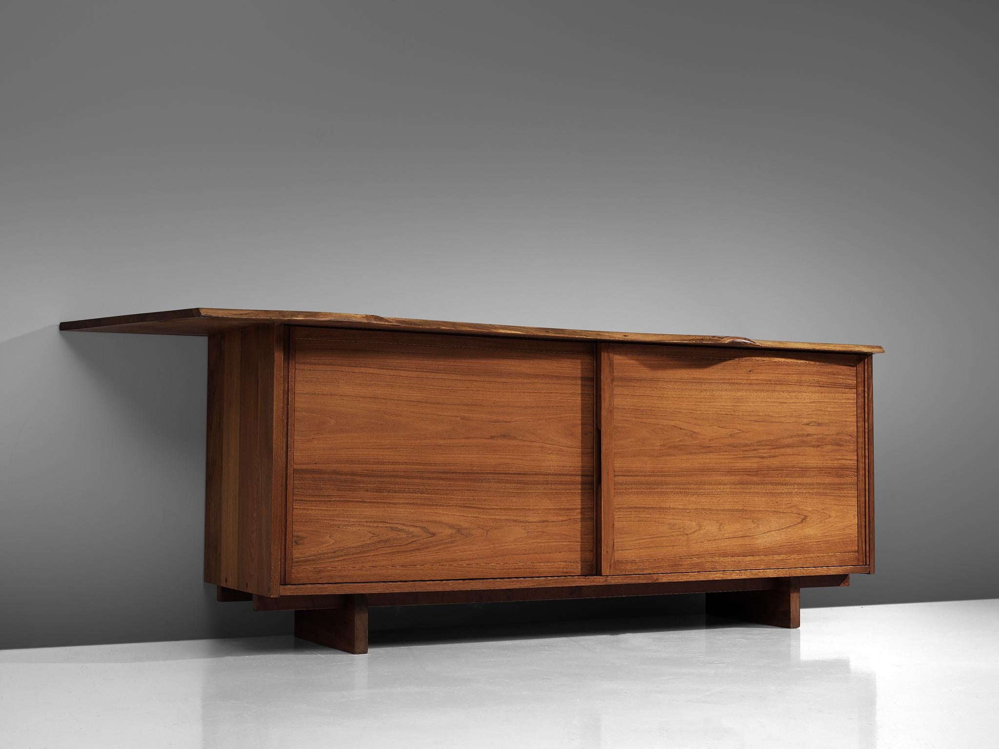 George Nakashima, sideboard, American walnut, United States, 1958

This cabinet by George Nakashima features sliding drawers, and a large slab spanning past the edges of the cabinet. Nakashima designed the piece to express the character of this
