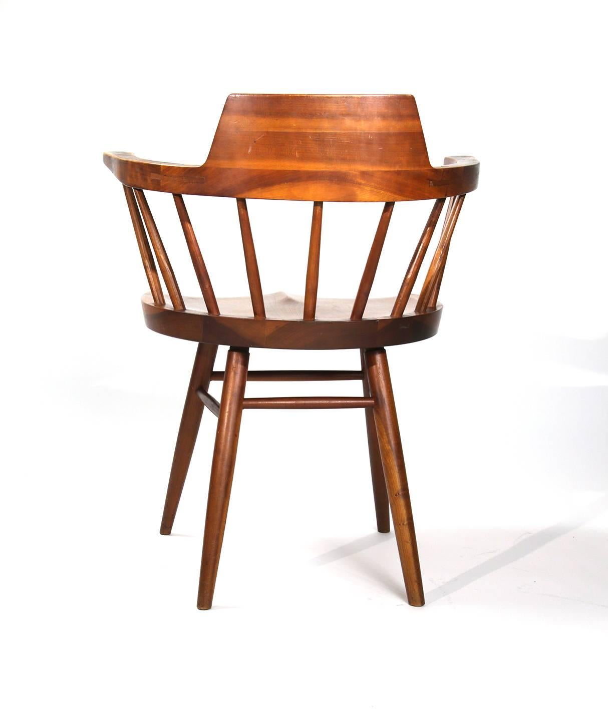 George Nakashima black walnut captain's chair with hand carved seat and spindles. Classic Nakashima splayed legs. A beautiful example. Small restoration.
