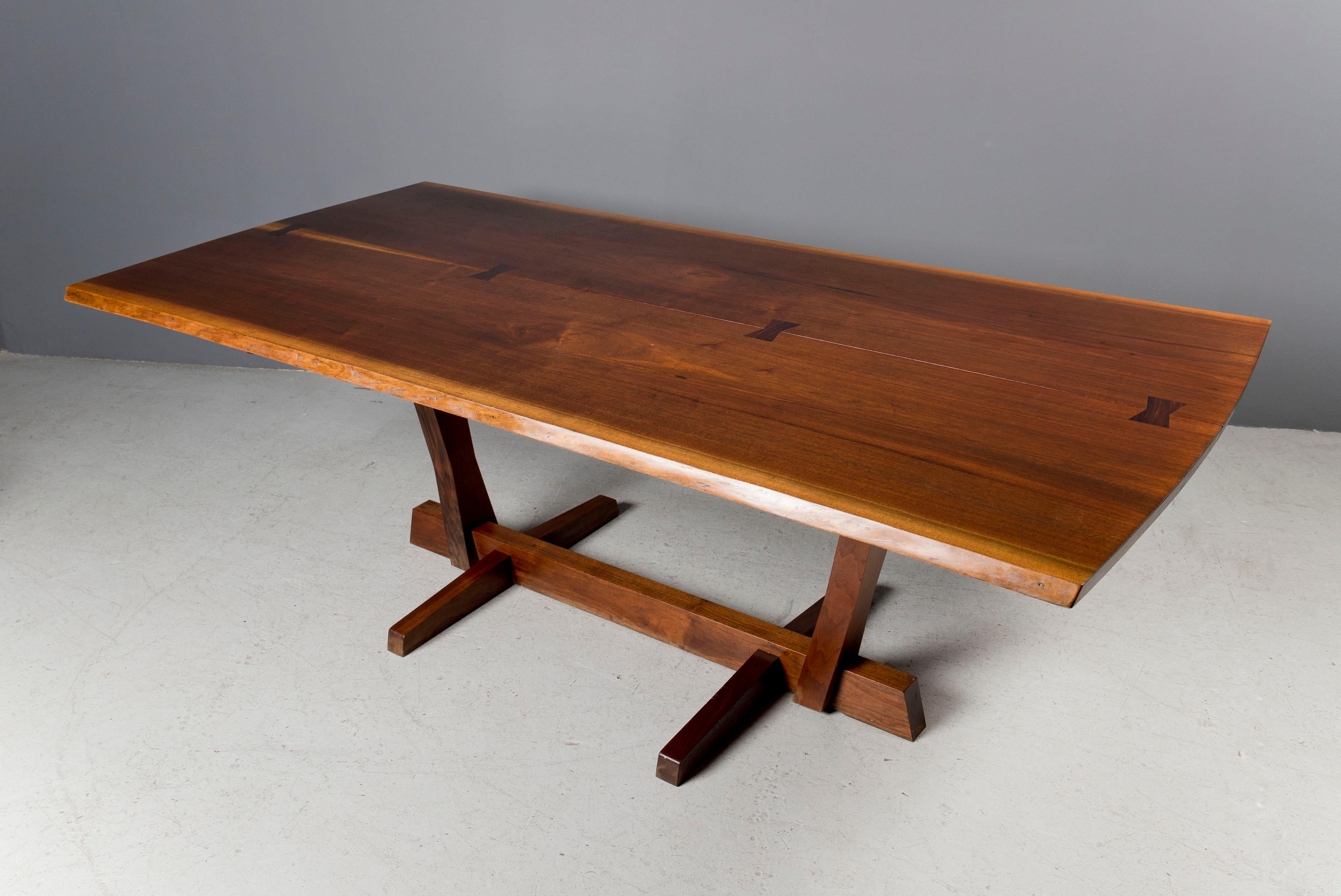 Exquisite two slab black walnut George Nakashima conoid base dining table. The top is book matched and features four rosewood butterflies. 

A digital copy of the original order card is available upon request.