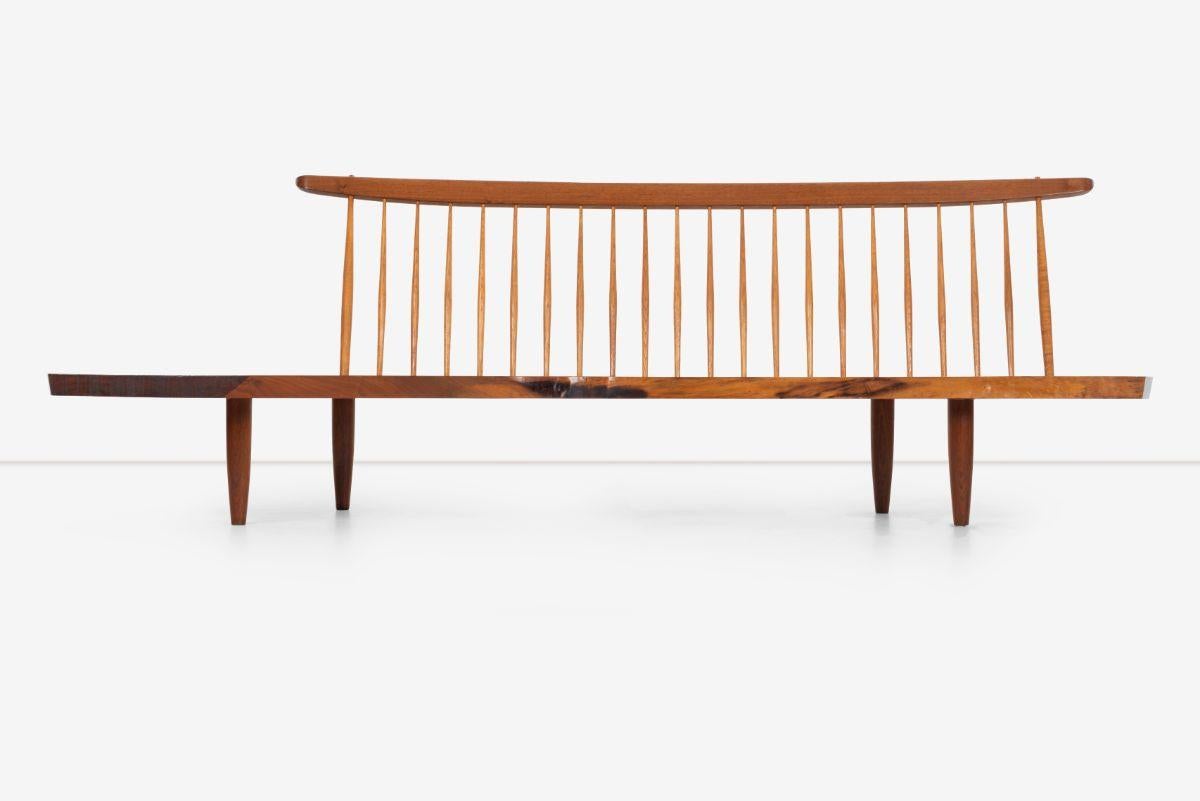 George Nakashima Conoid bench 1973, features; Curved crest-rail with twenty-two hickory spindles, solid black walnut plank seat with two rosewood butterfly joints. Distinctive graining and shape.