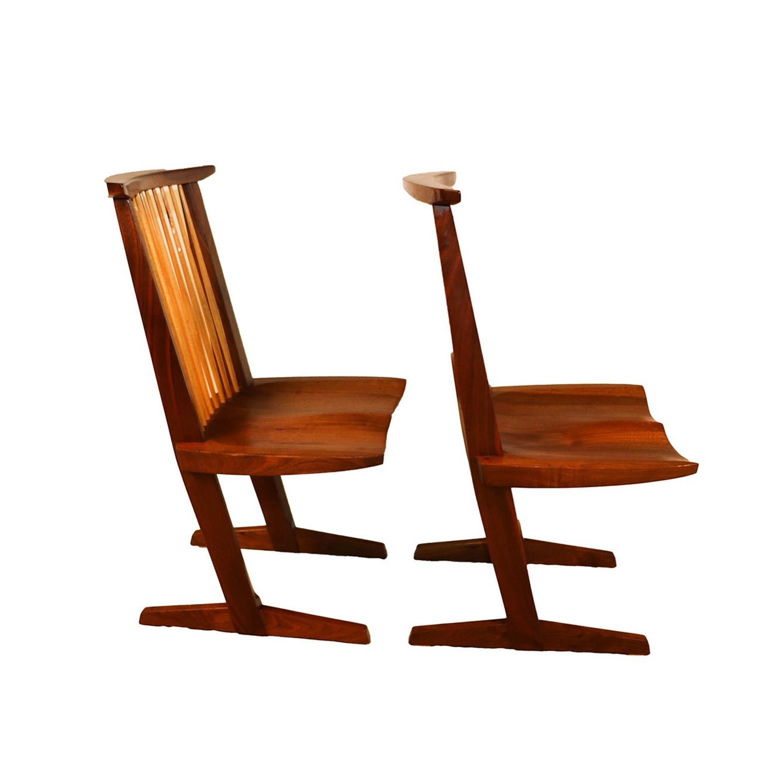 Designed by George Nakashima in 1985. This gorgeous pair of clean and solid sculptural chairs have been well cared for over the years, in original condition. Features walnut and hickory spindled backs, flat curved crest rails, a beautiful selection